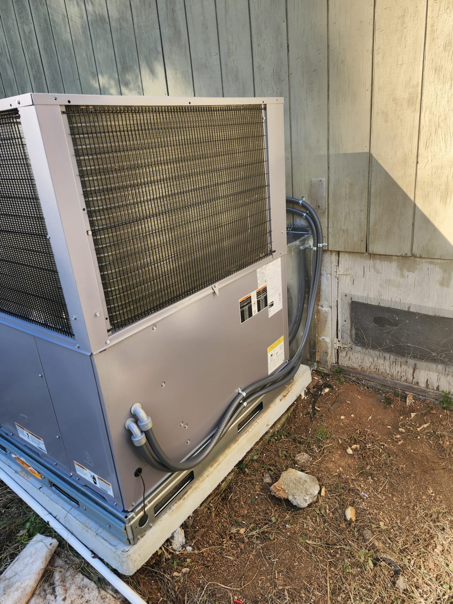 New HVAC unit installed on a concrete pad