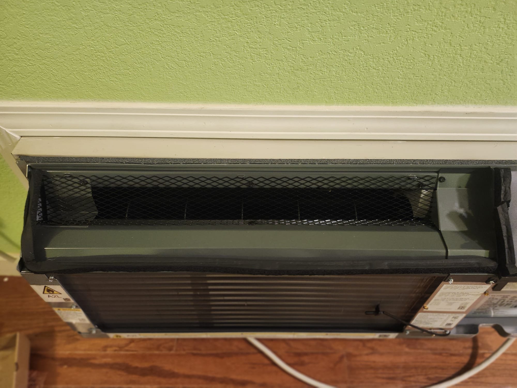A newly installed mini-split unit mounted near the base of an interior wall