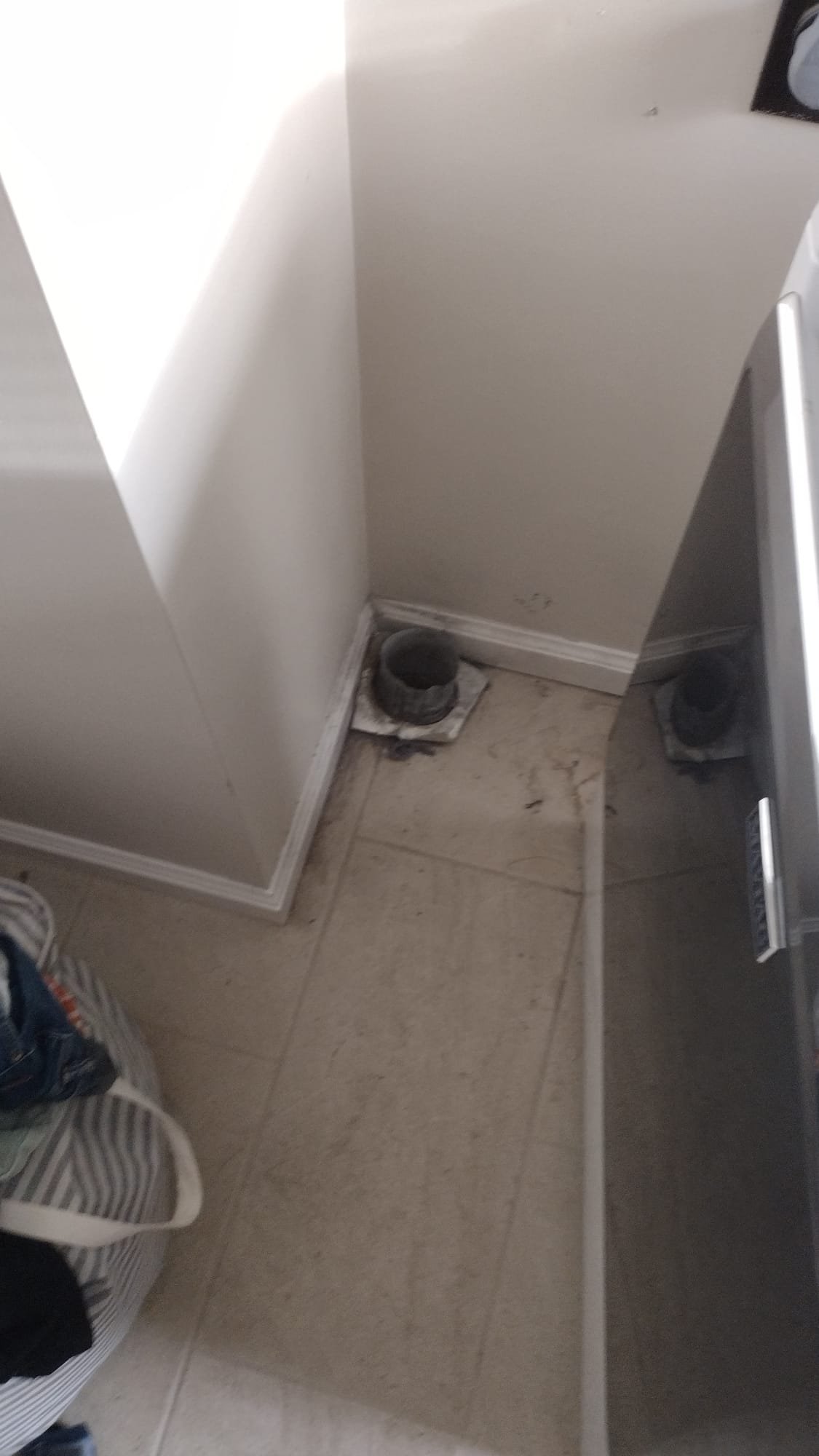 Laundry area with exposed floor vents before upgrade