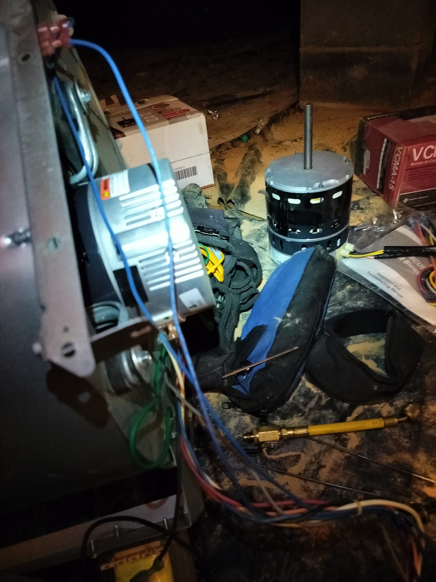 Old and new blower motor side by side during replacement