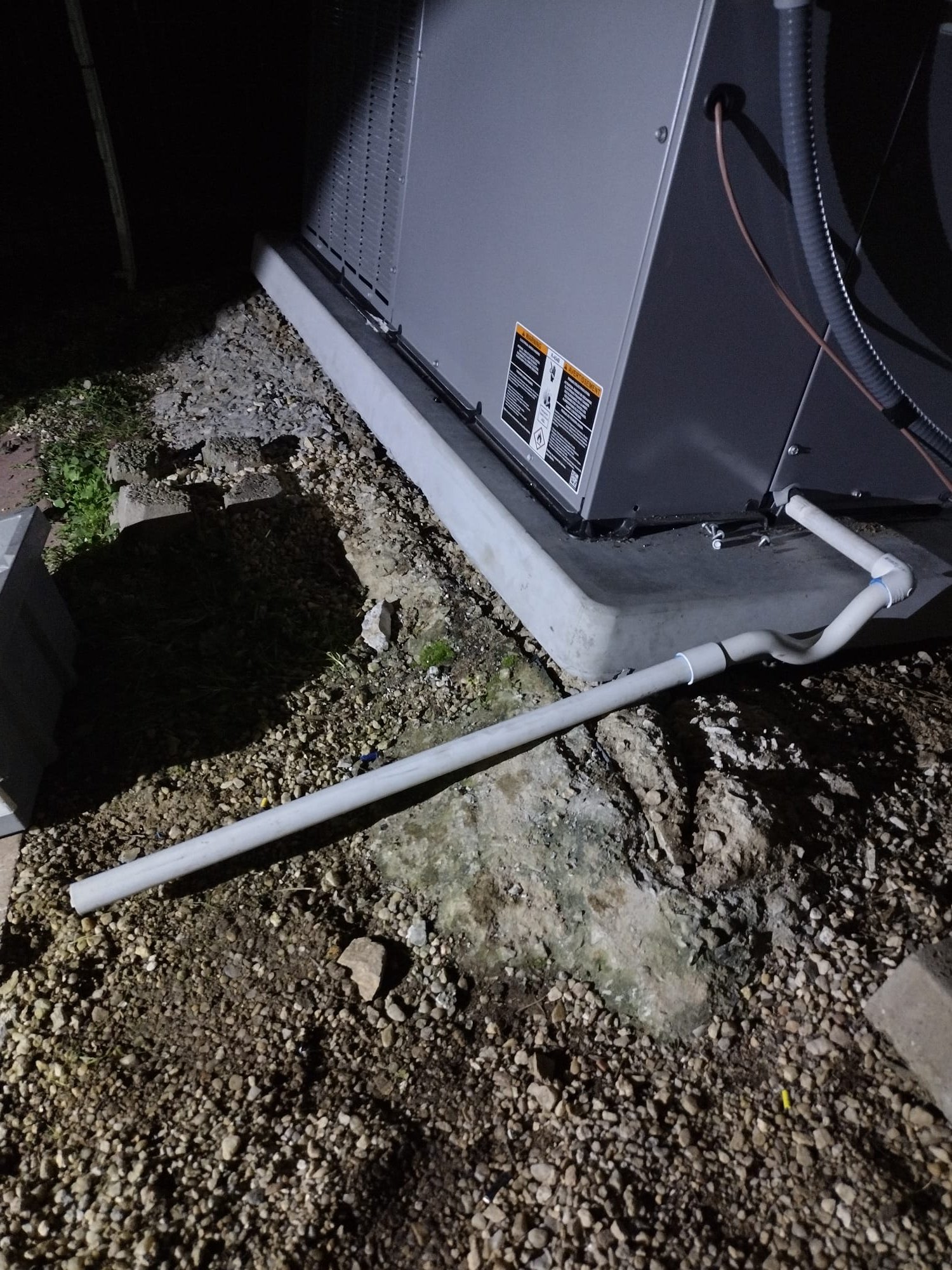 Outdoor unit with proper condensate piping and sturdy electrical connections