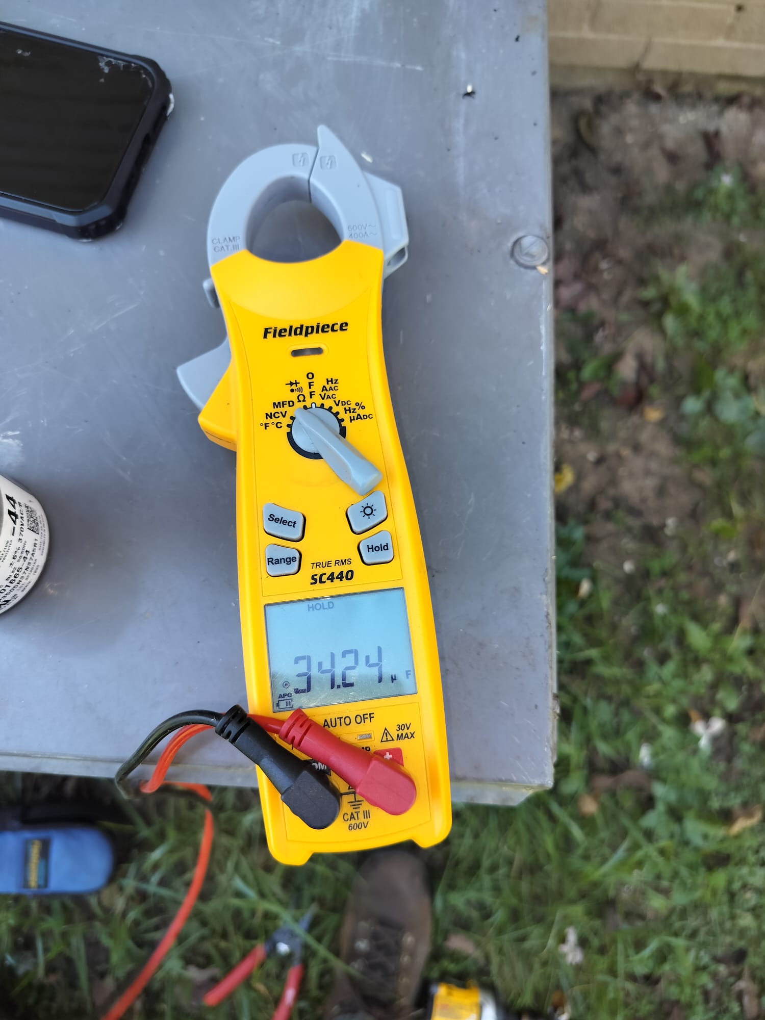 Clamp meter measuring electrical current on an HVAC system
