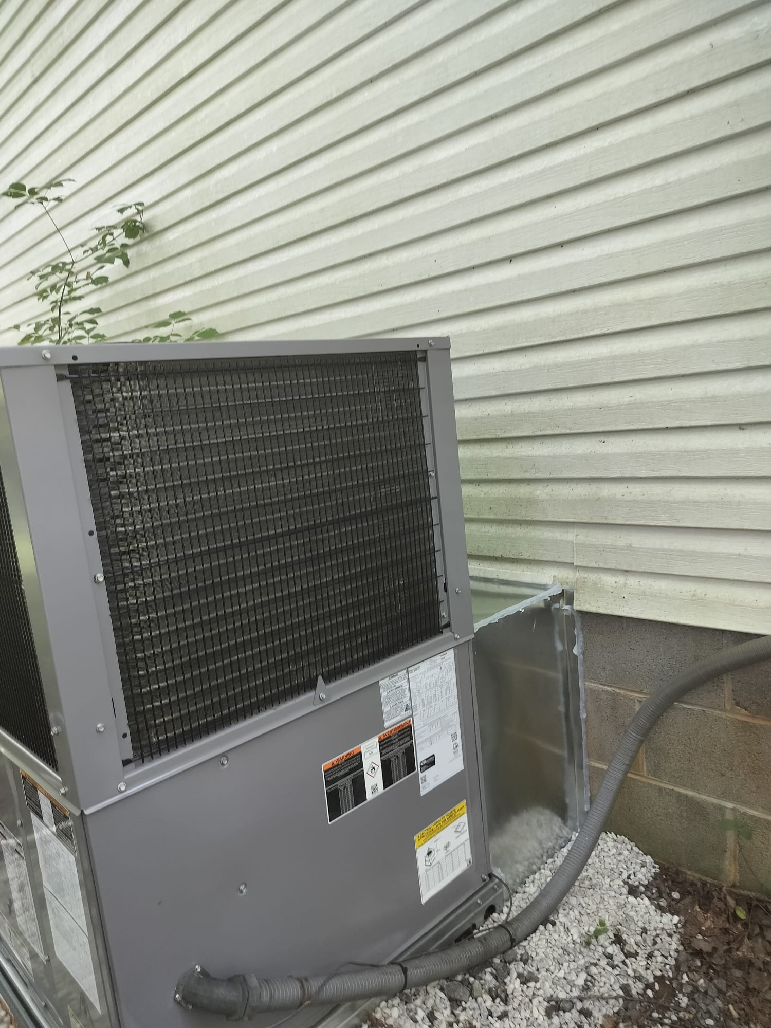 Freshly installed heat pump on a tidy gravel surface