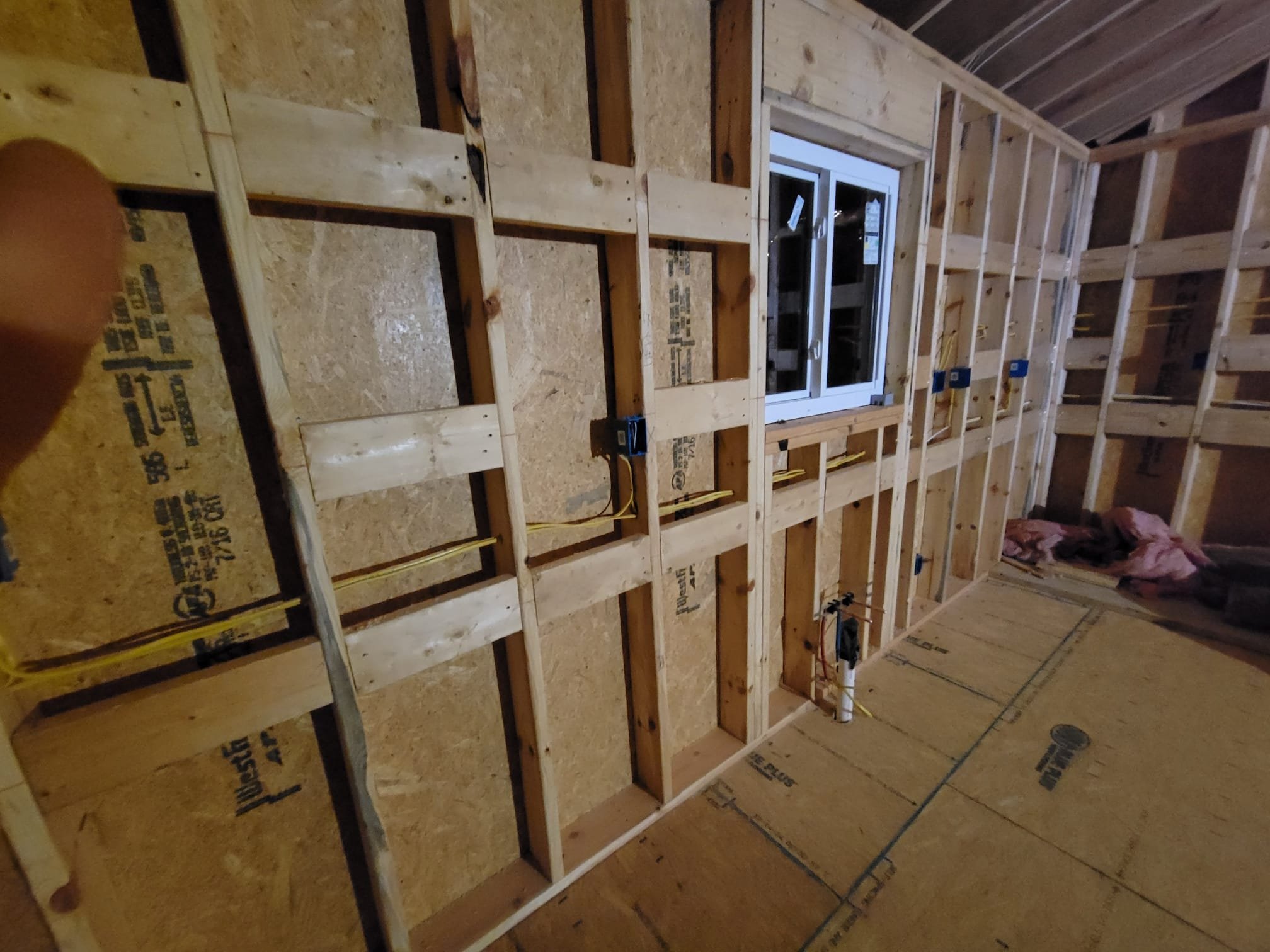 Interior framing with new wiring and plumbing ready for inspection