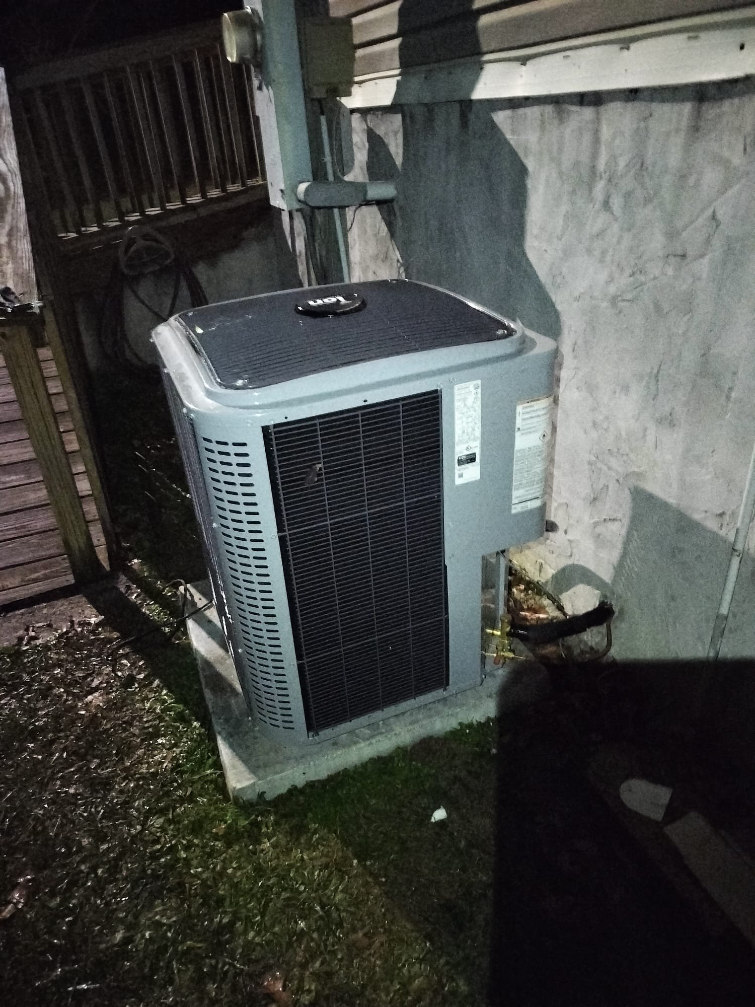 New outdoor condenser unit installed on concrete pad.