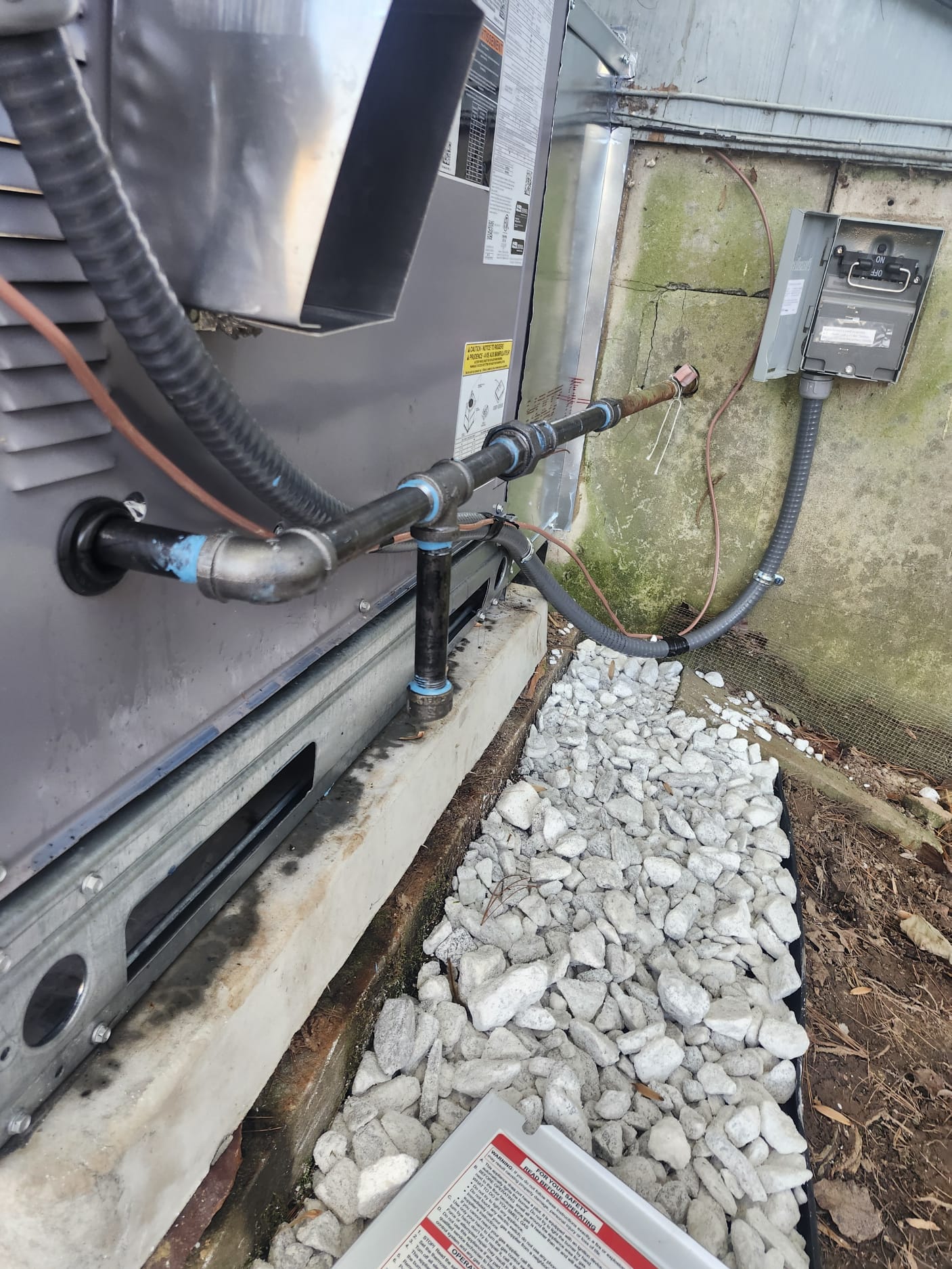 New gas/refrigerant piping and electrical disconnect box installed during HVAC replacement.