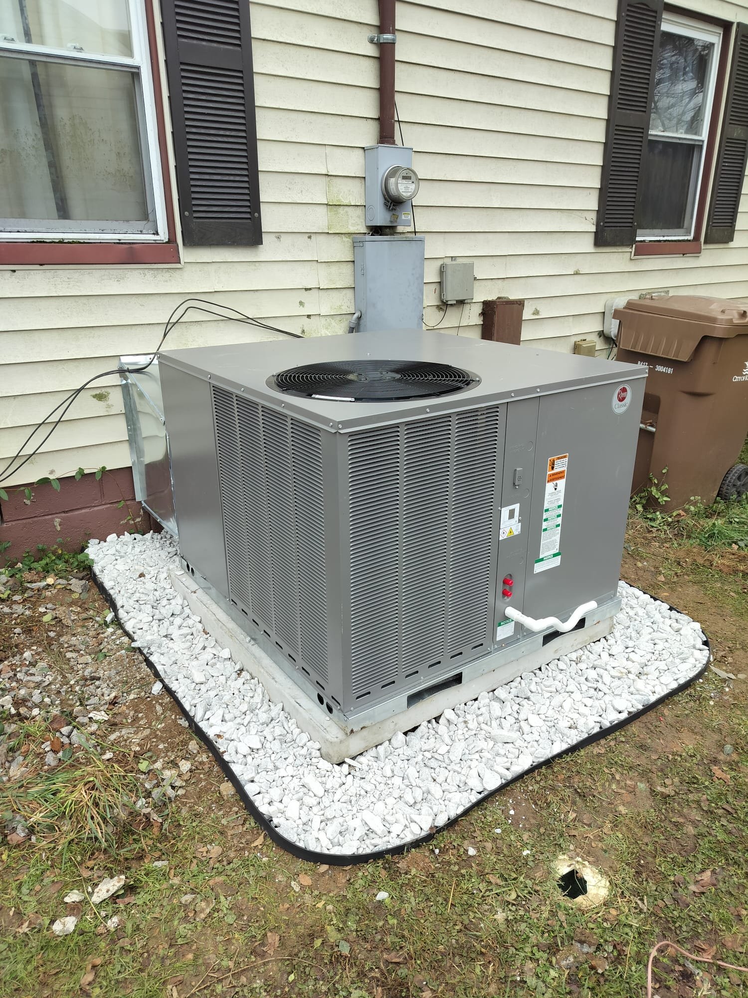 Brand-new heat pump package unit installed on gravel bed