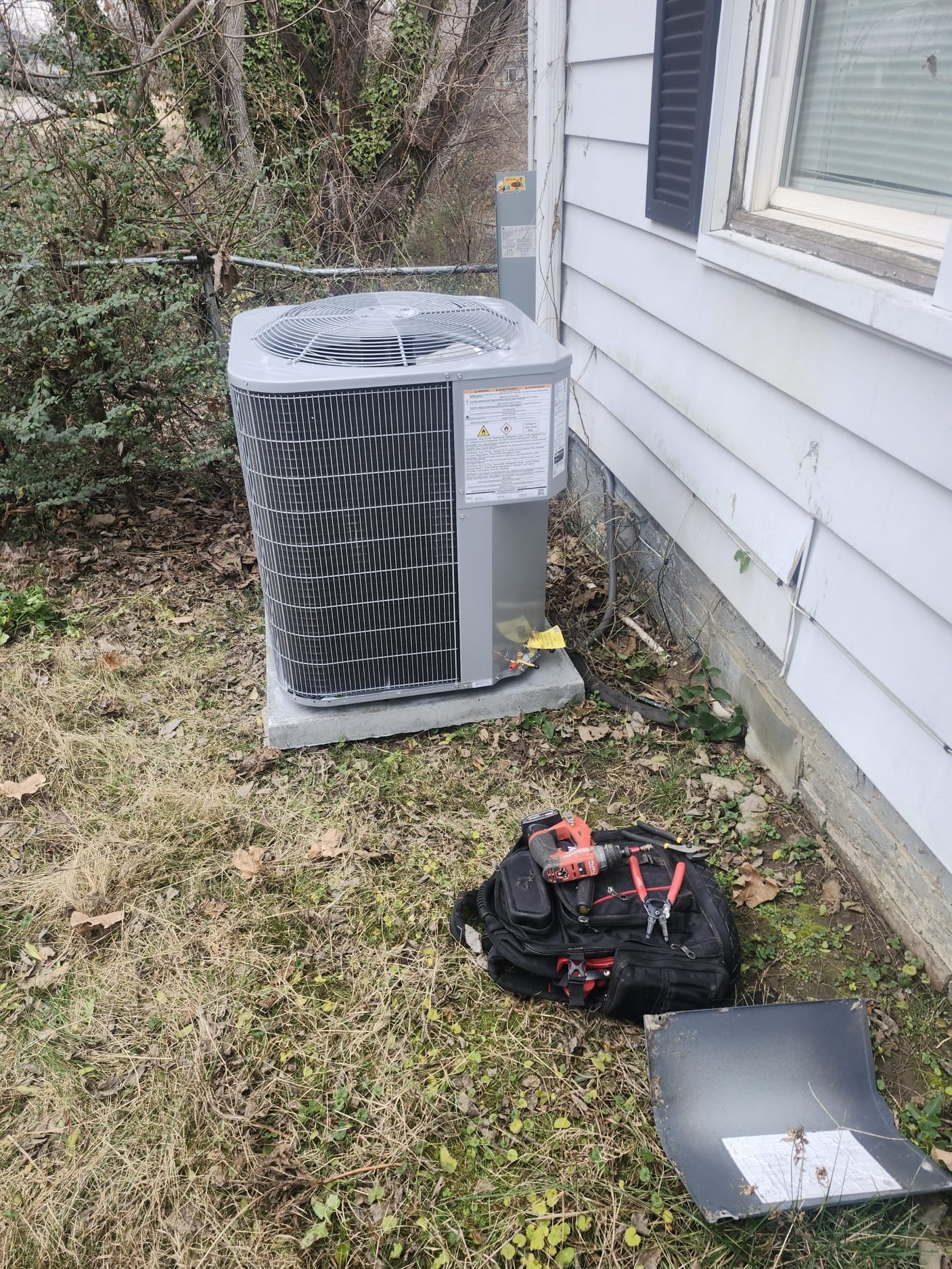 Outdoor unit installation in progress with technician tools nearby