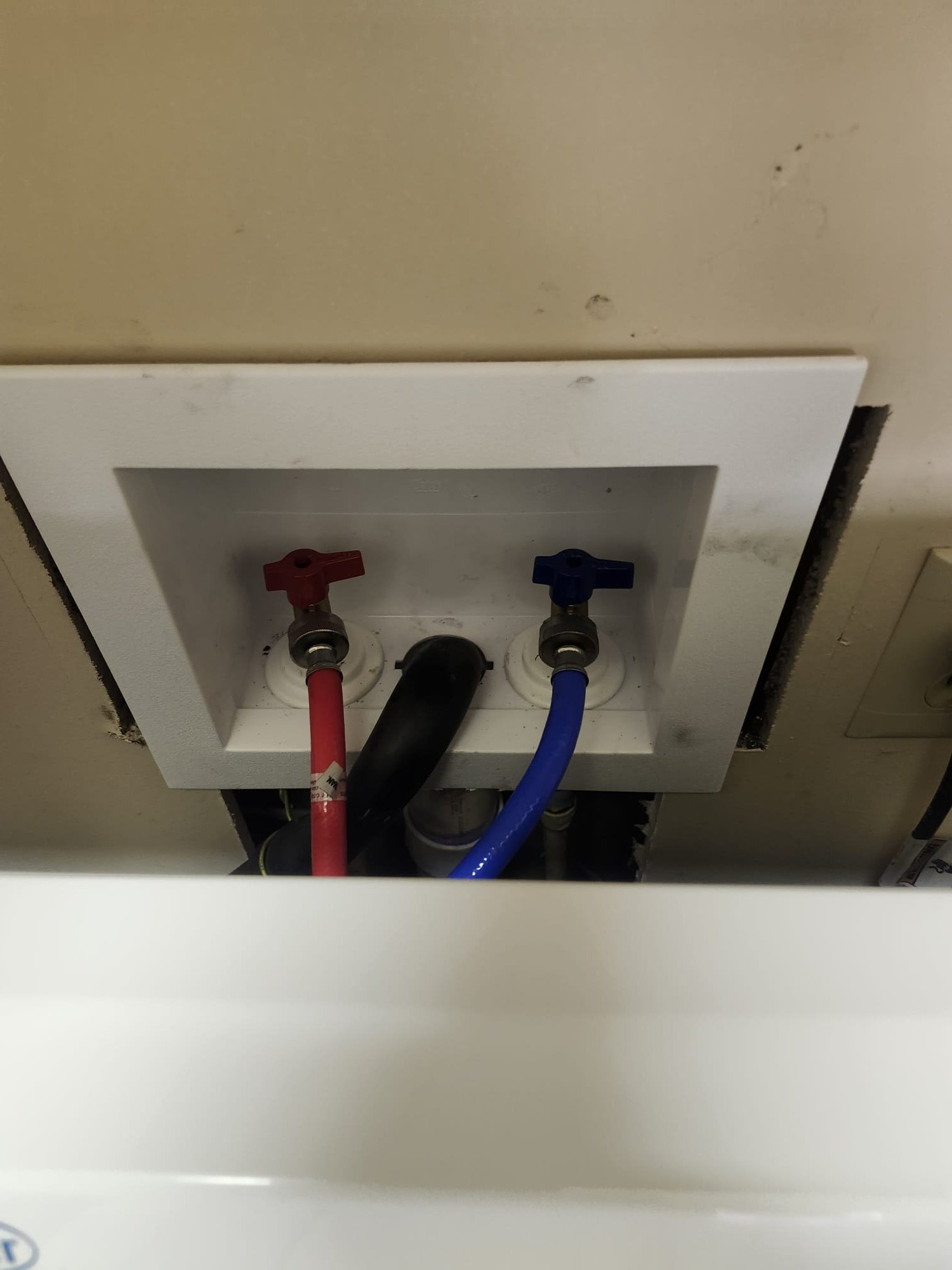 Old washer supply box with signs of water damage and mold