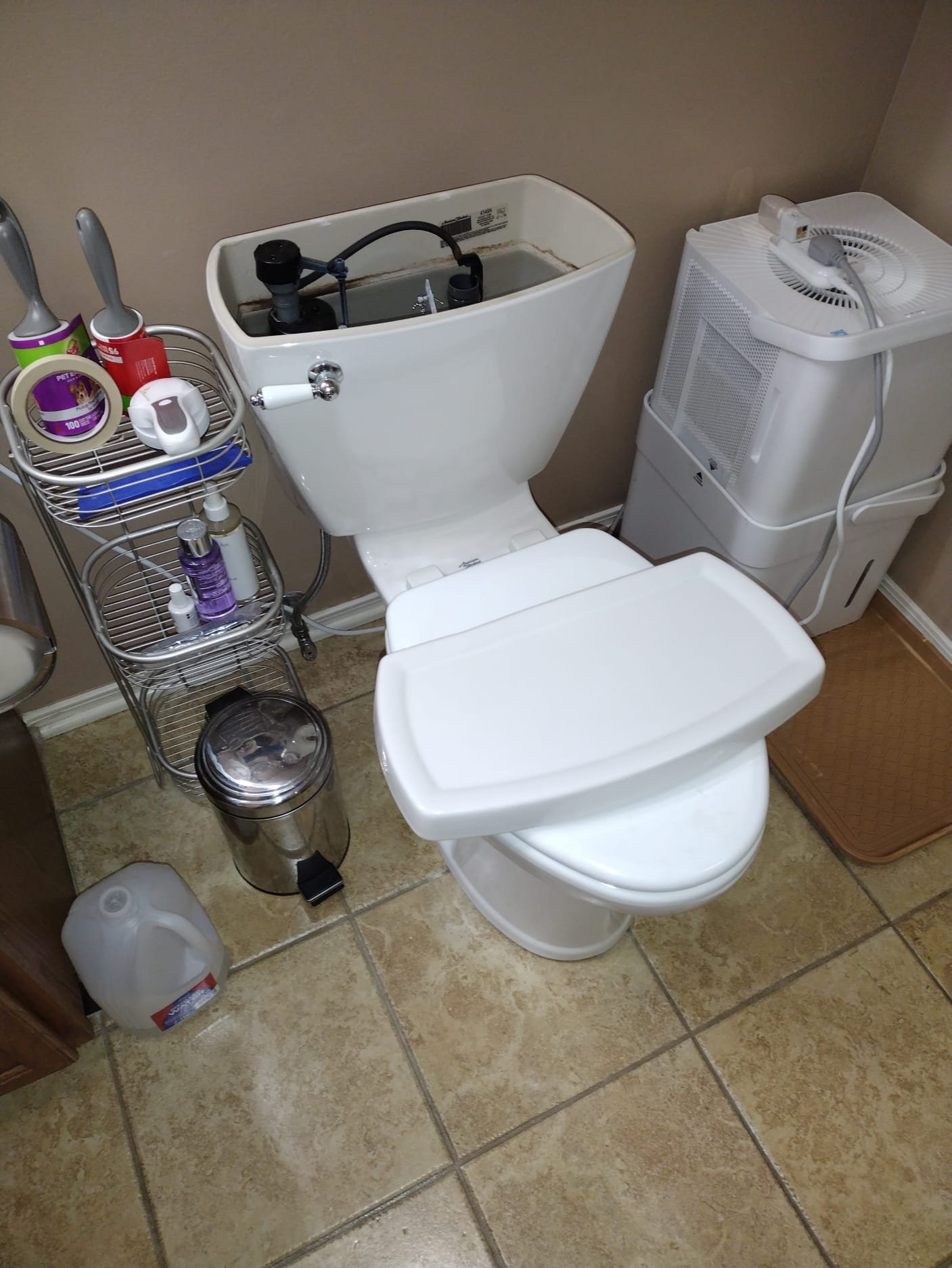 Well-maintained toilet tank with new components and organized supplies nearby
