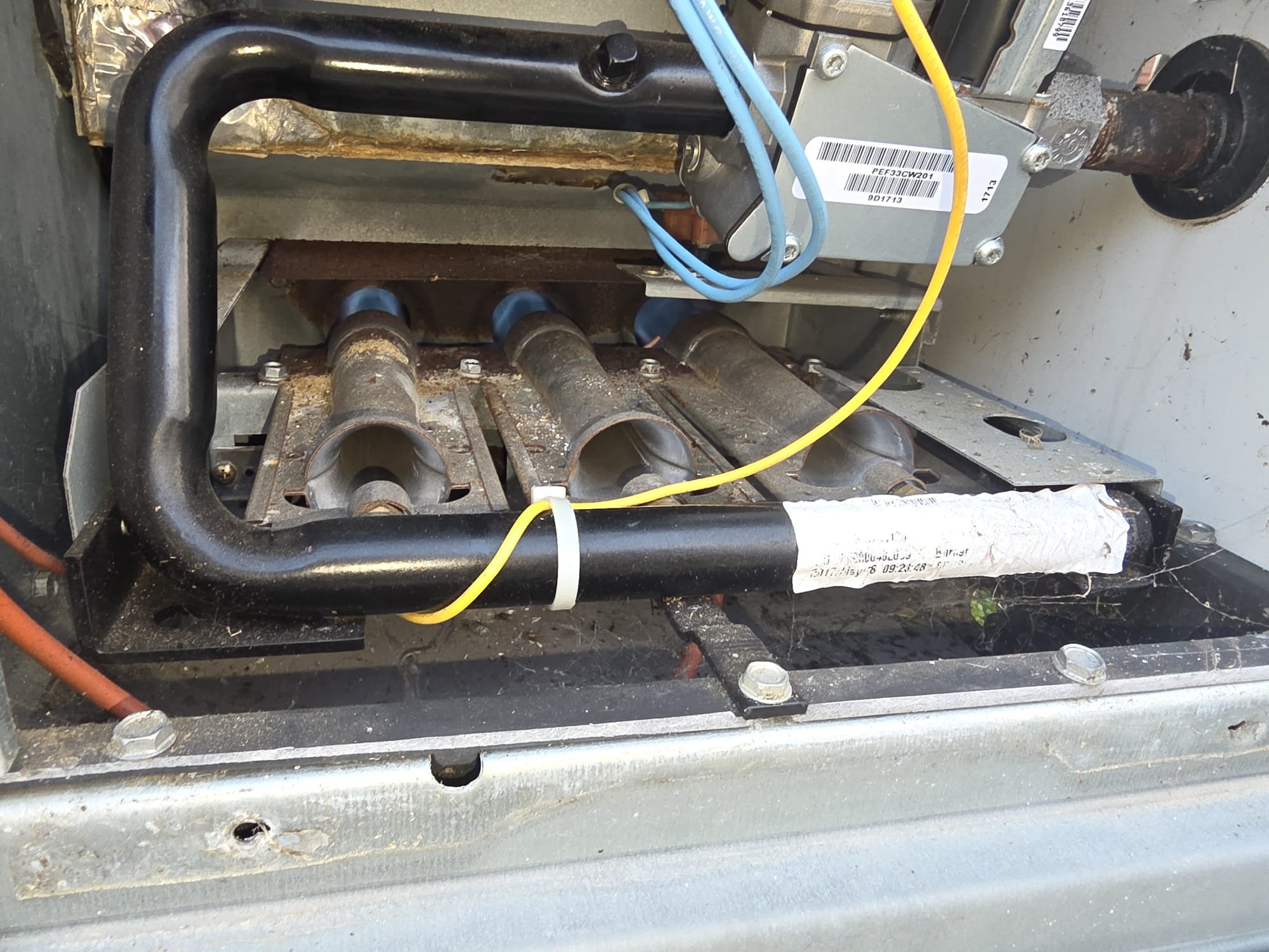 This image shows the interior of an HVAC furnace unit, specifically focusing on the burner assembly and associated wiring.