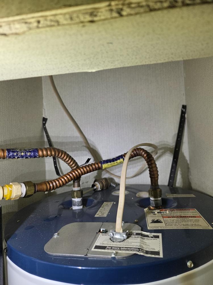 Cleanly installed water heater with insulated copper lines and no signs of leakage