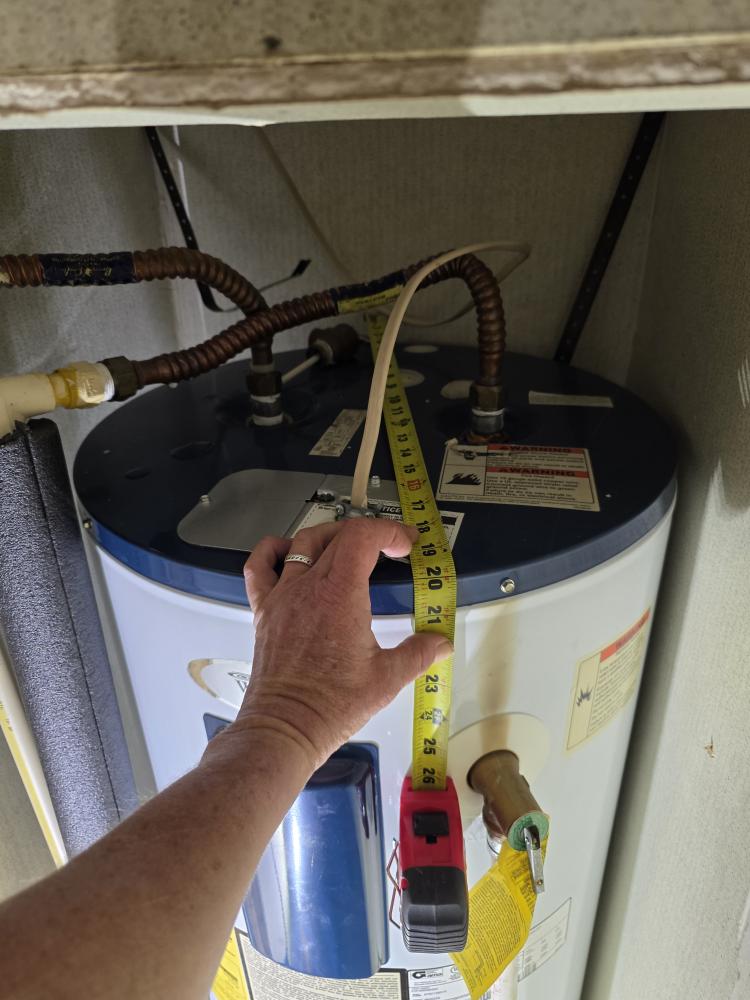 Close-up of HEP technician checking clearance at the top of a water heater