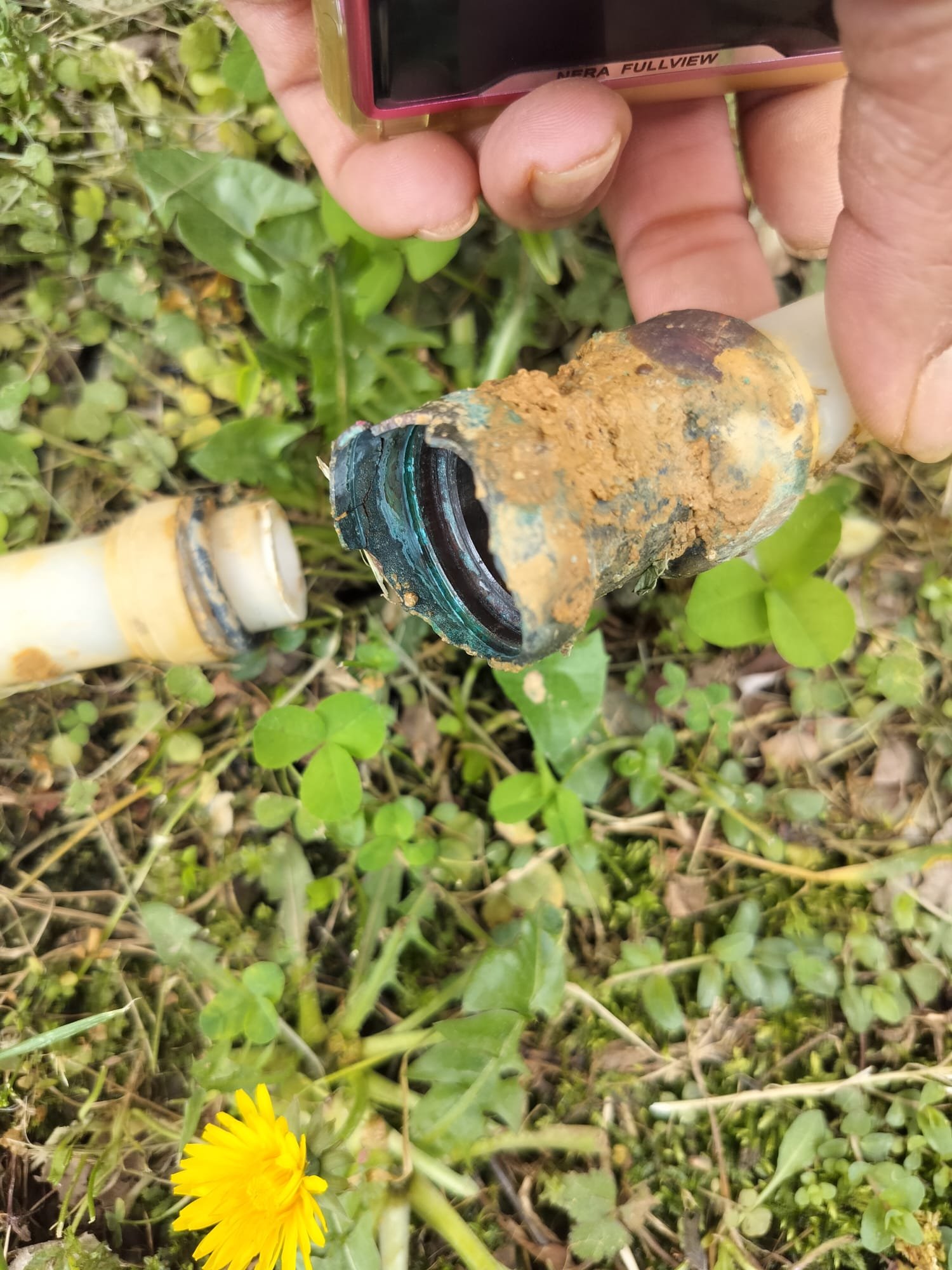 Close-up of a broken joint on an outdoor water line before repair