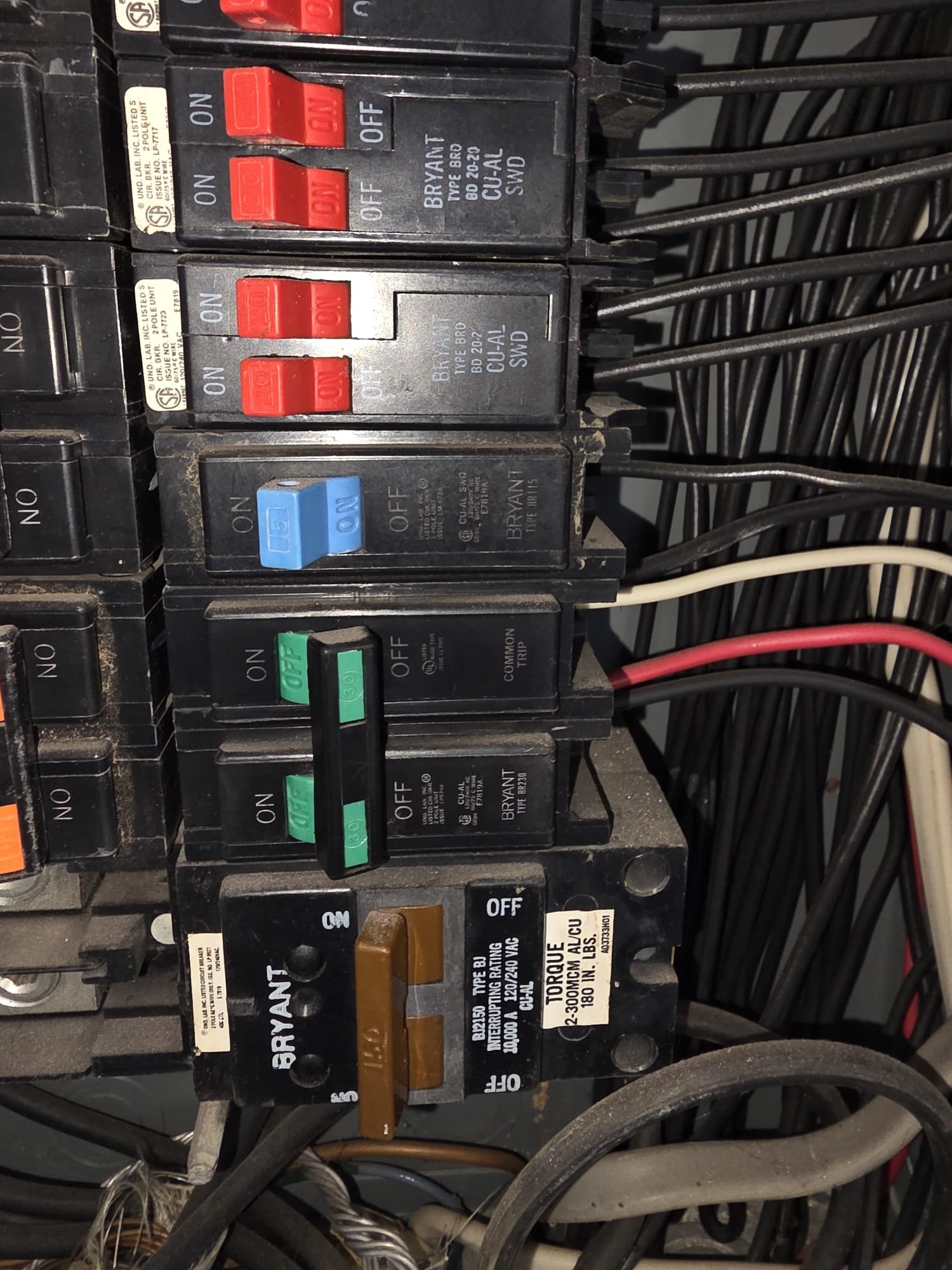 Inside view of a residential breaker panel with multiple color-coded breakers