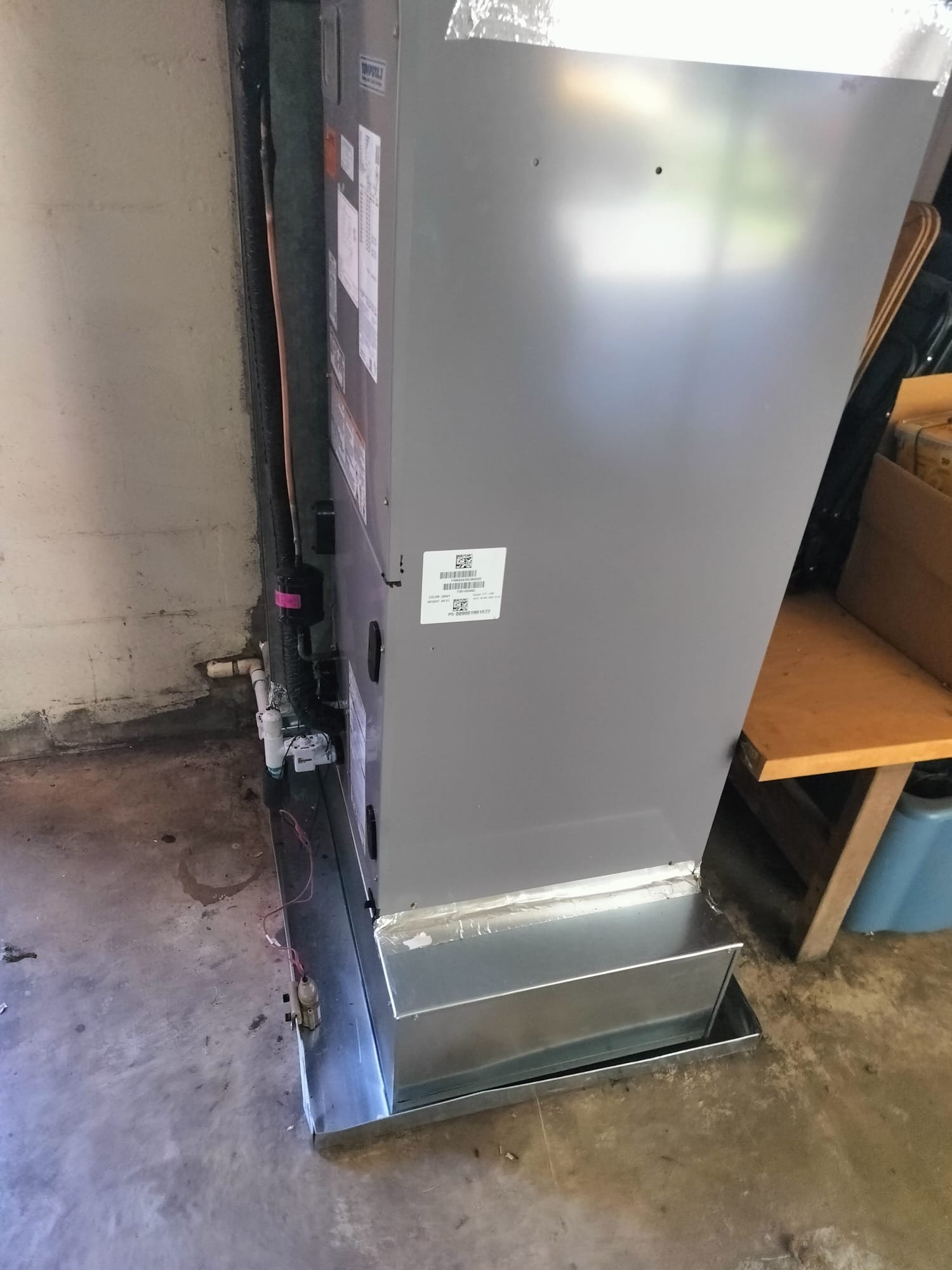 Newly installed HVAC air handler unit on a metal drain pan