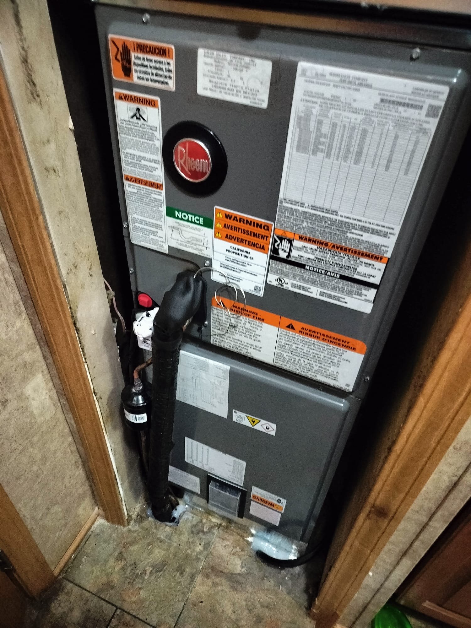 New Rheem outdoor condenser unit installed on a gravel pad