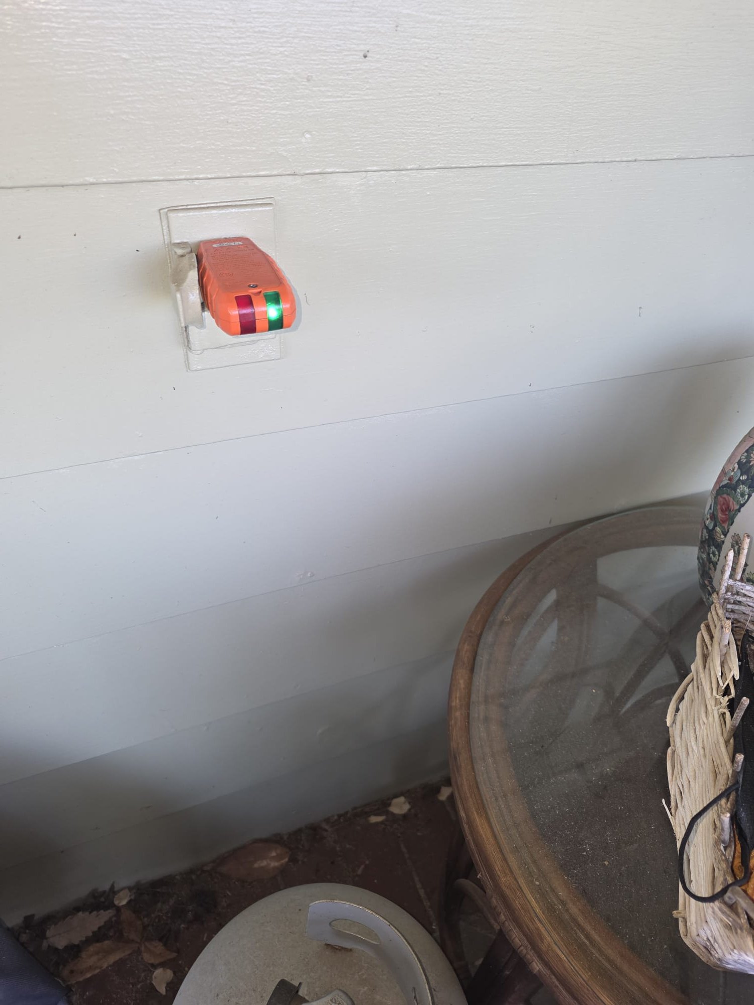 Outlet tester confirming proper wiring in a patio receptacle.