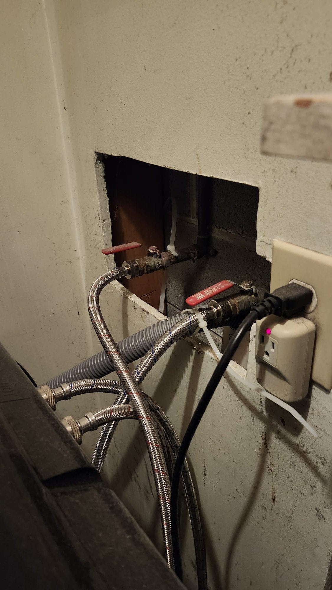 Freshly installed braided hoses and valves in a utility room