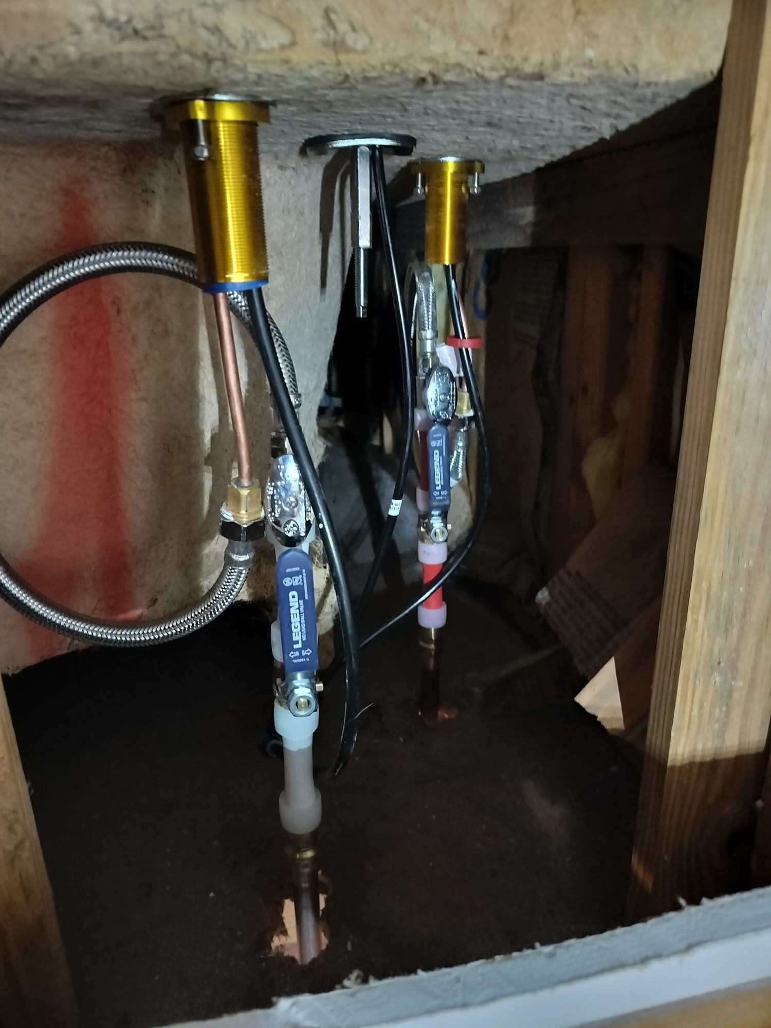 New plumbing valves and braided supply lines neatly installed under a sink