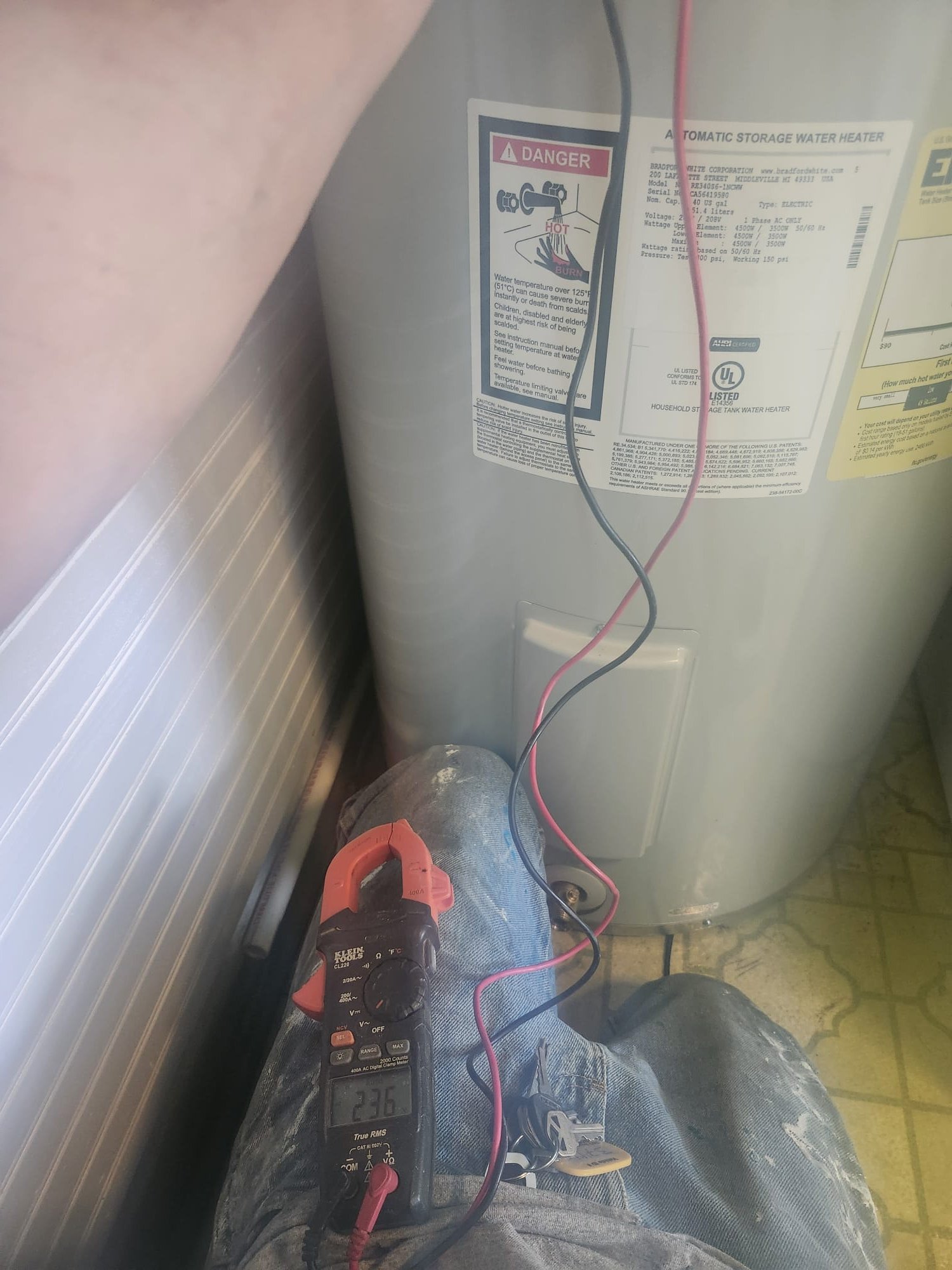 Technician measuring voltage on a storage water heater
