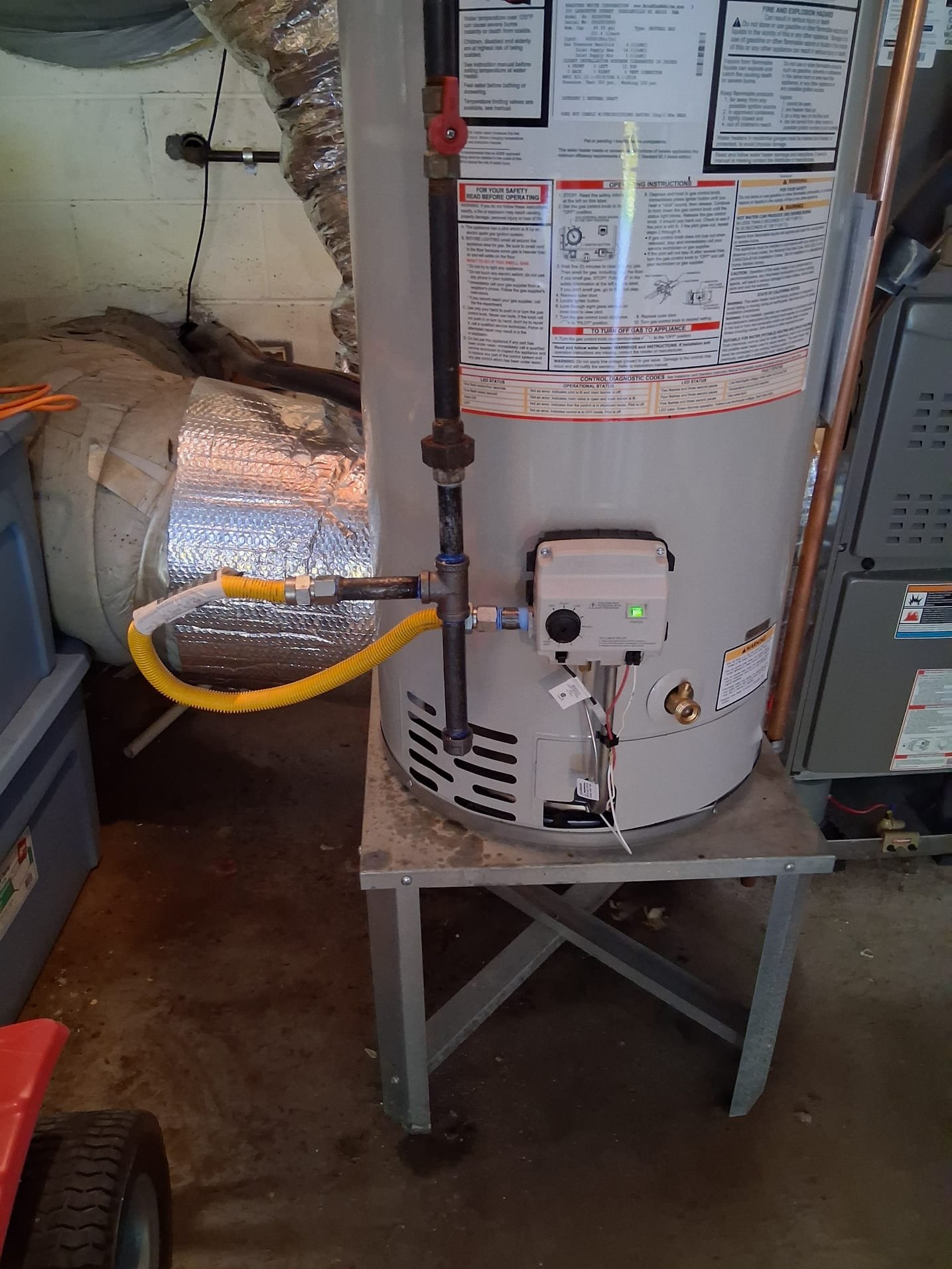 New gas-fired water heater on stand with secure gas line and venting