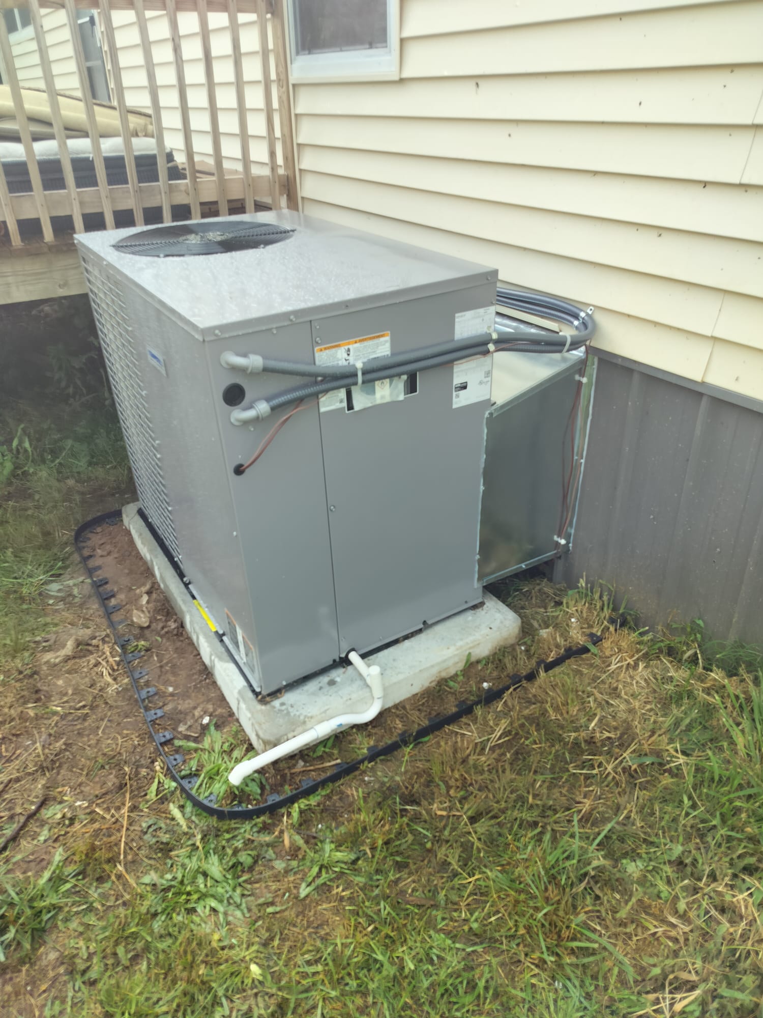 Newly installed HVAC condenser unit next to house