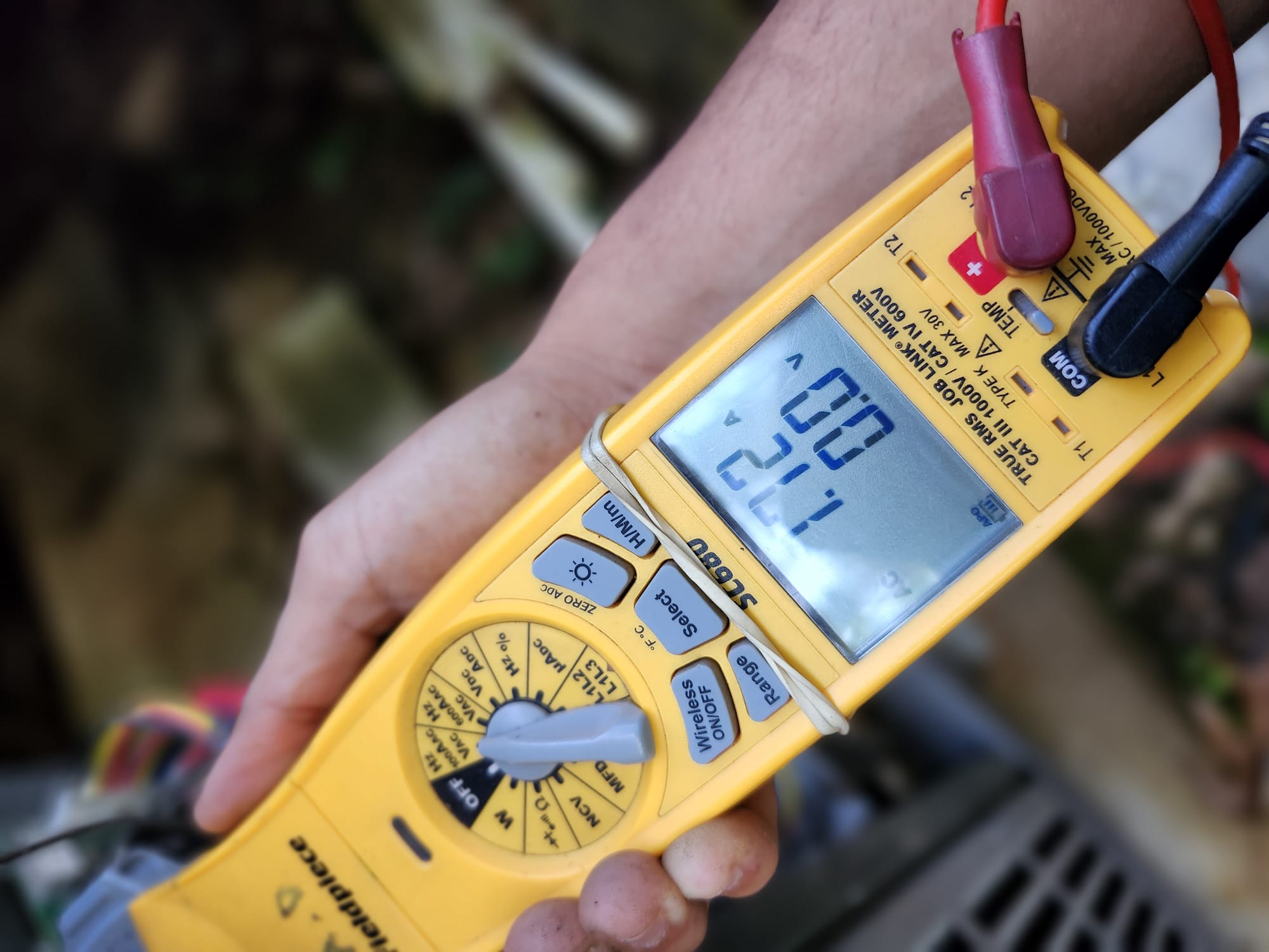 Technician using a clamp meter to confirm service success