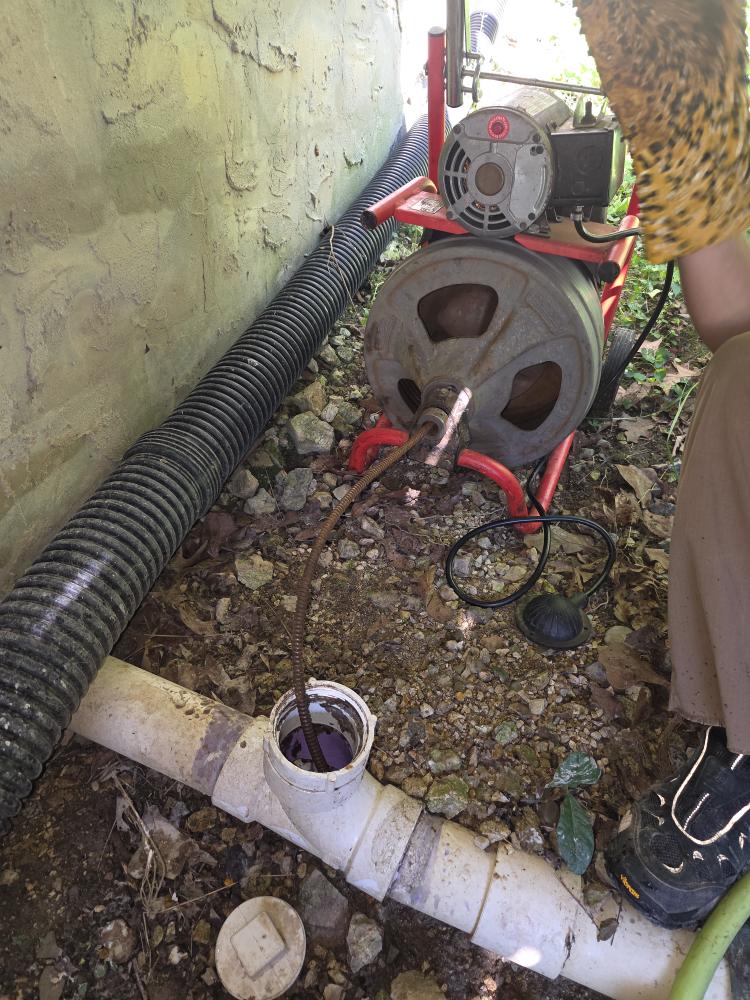 Using a drain-cleaning machine to clear a main sewer line