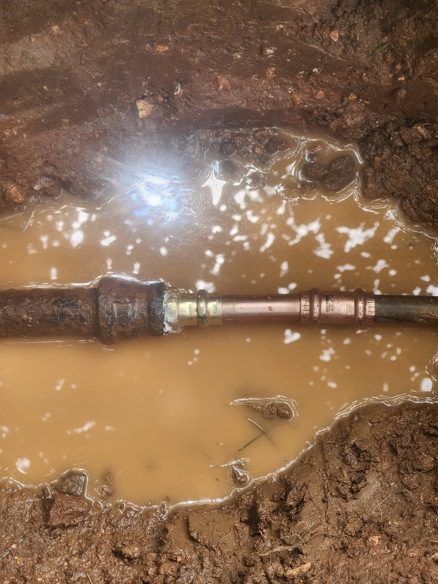 A repaired section of water line with newer piping and fittings