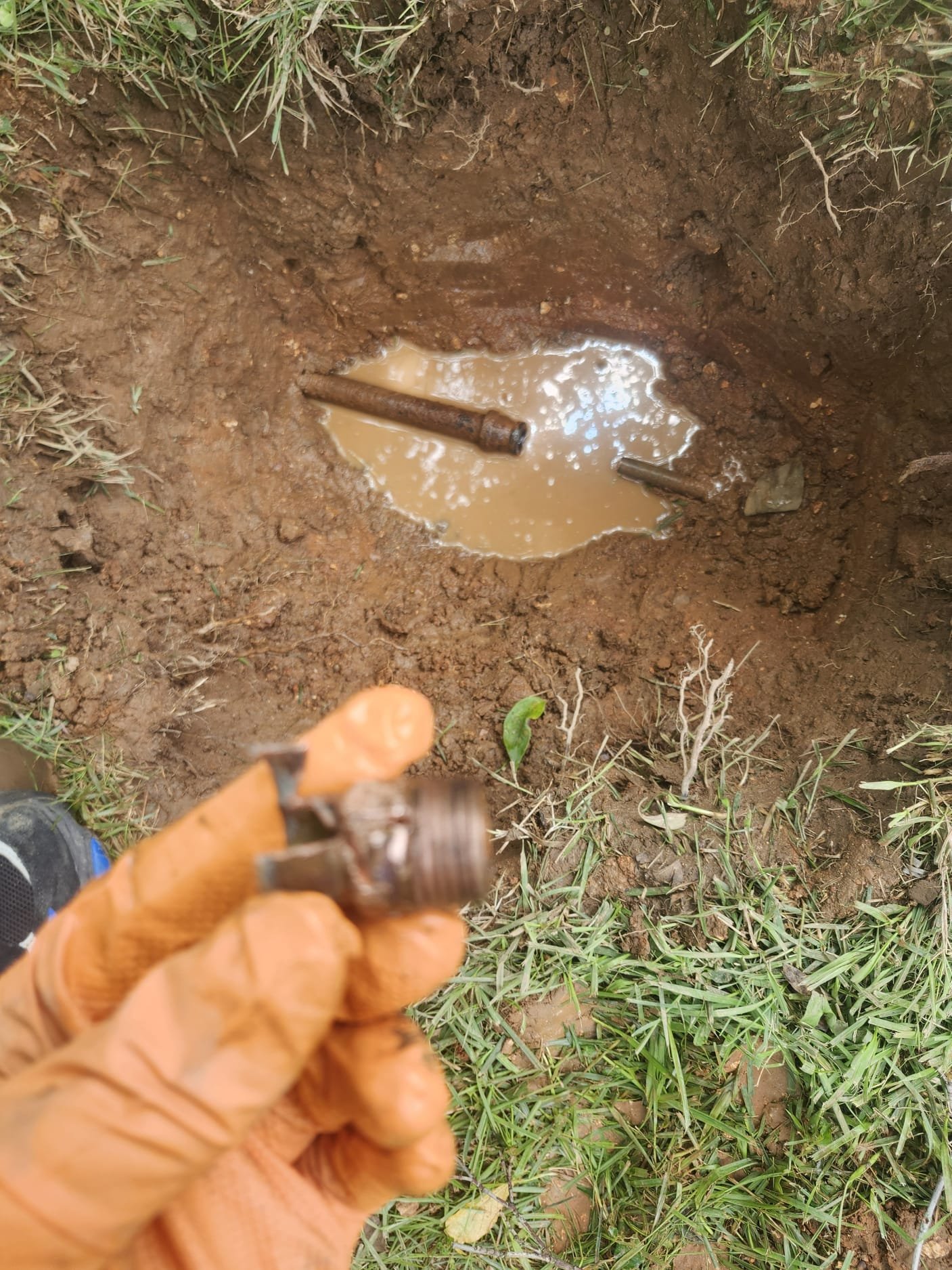 A damaged underground pipe connection being examined during repair