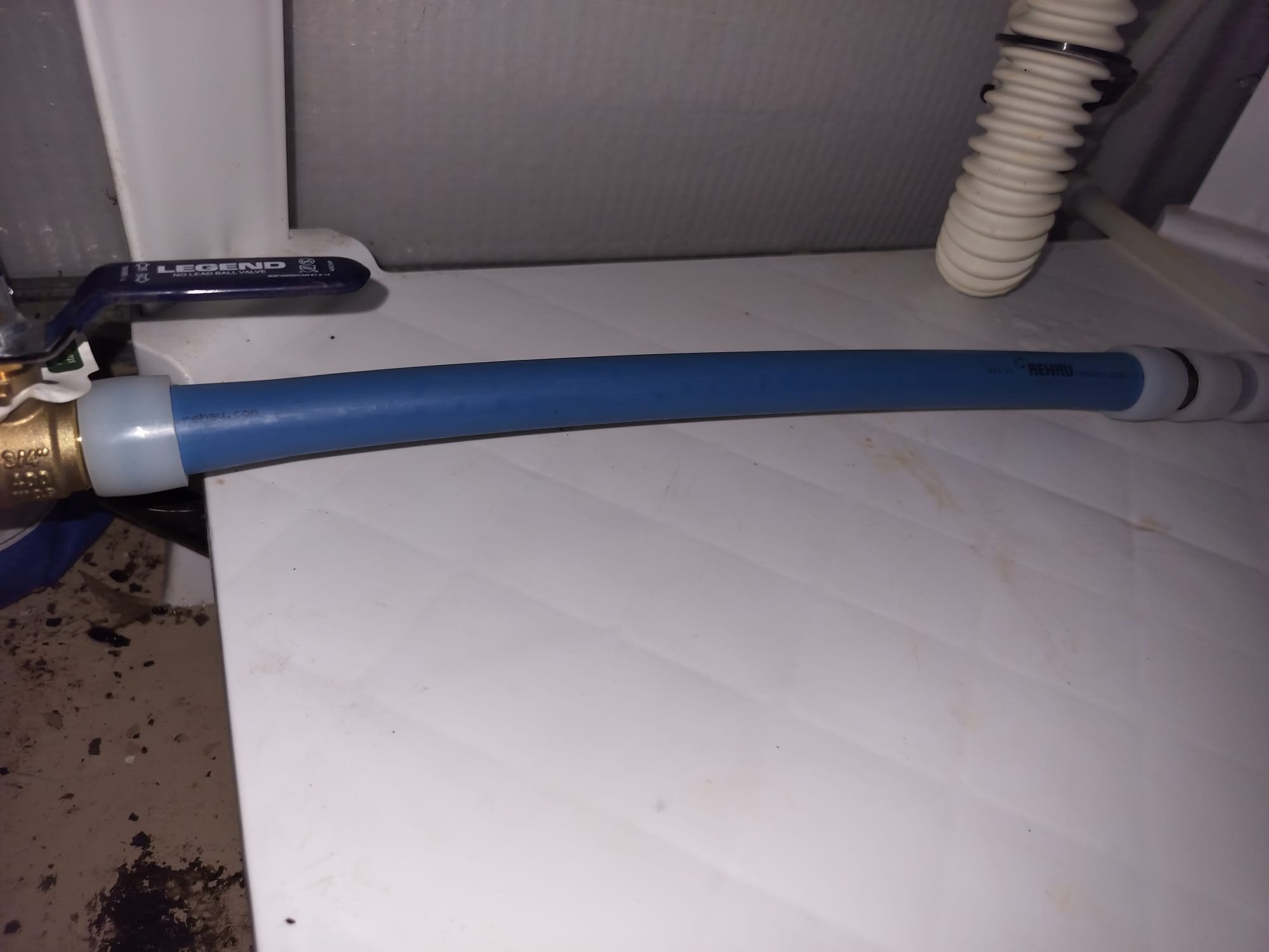 A newer flexible water line connected to a shutoff valve under a fixture.