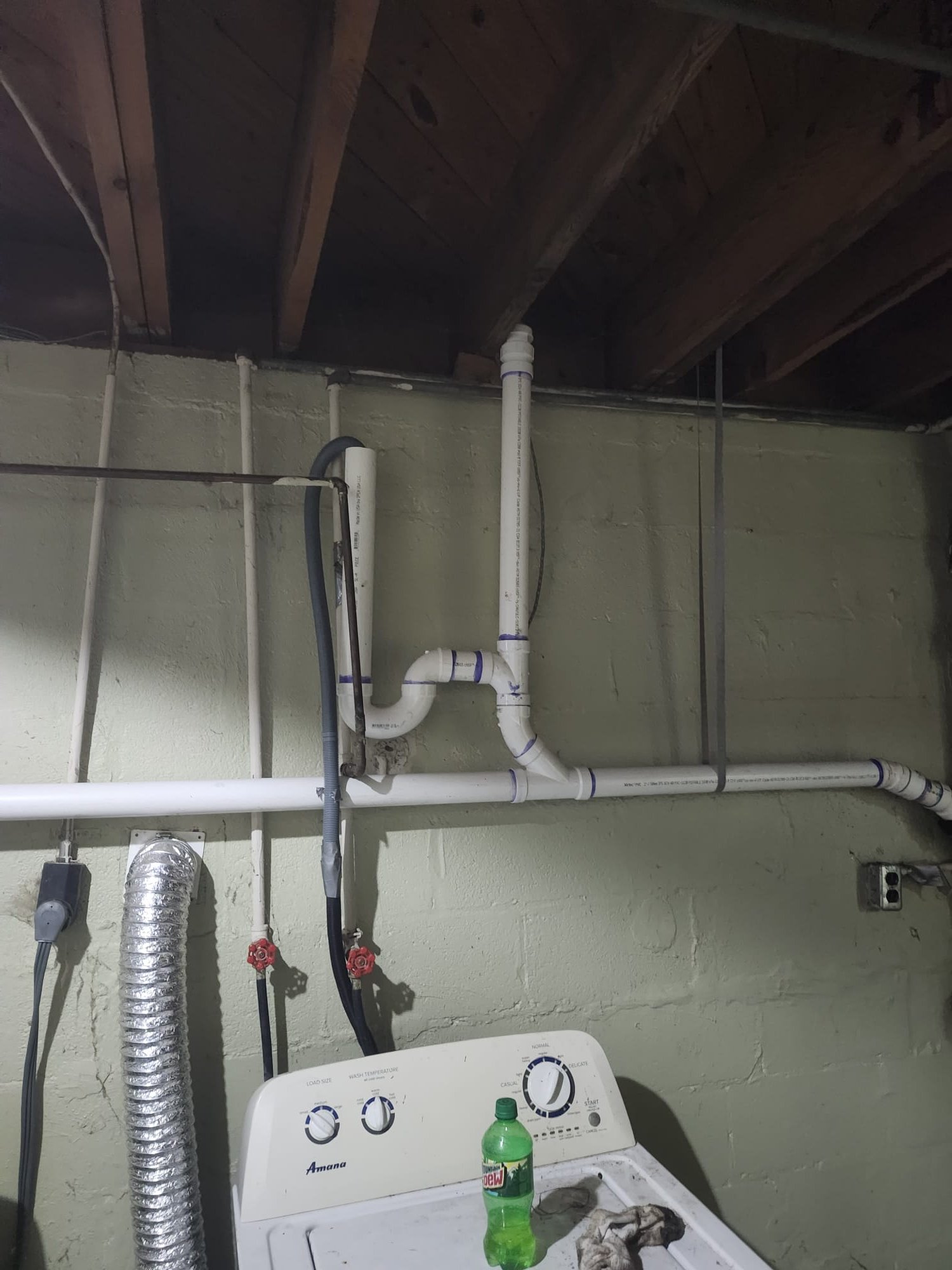 New PVC drain line installed in a basement utility area