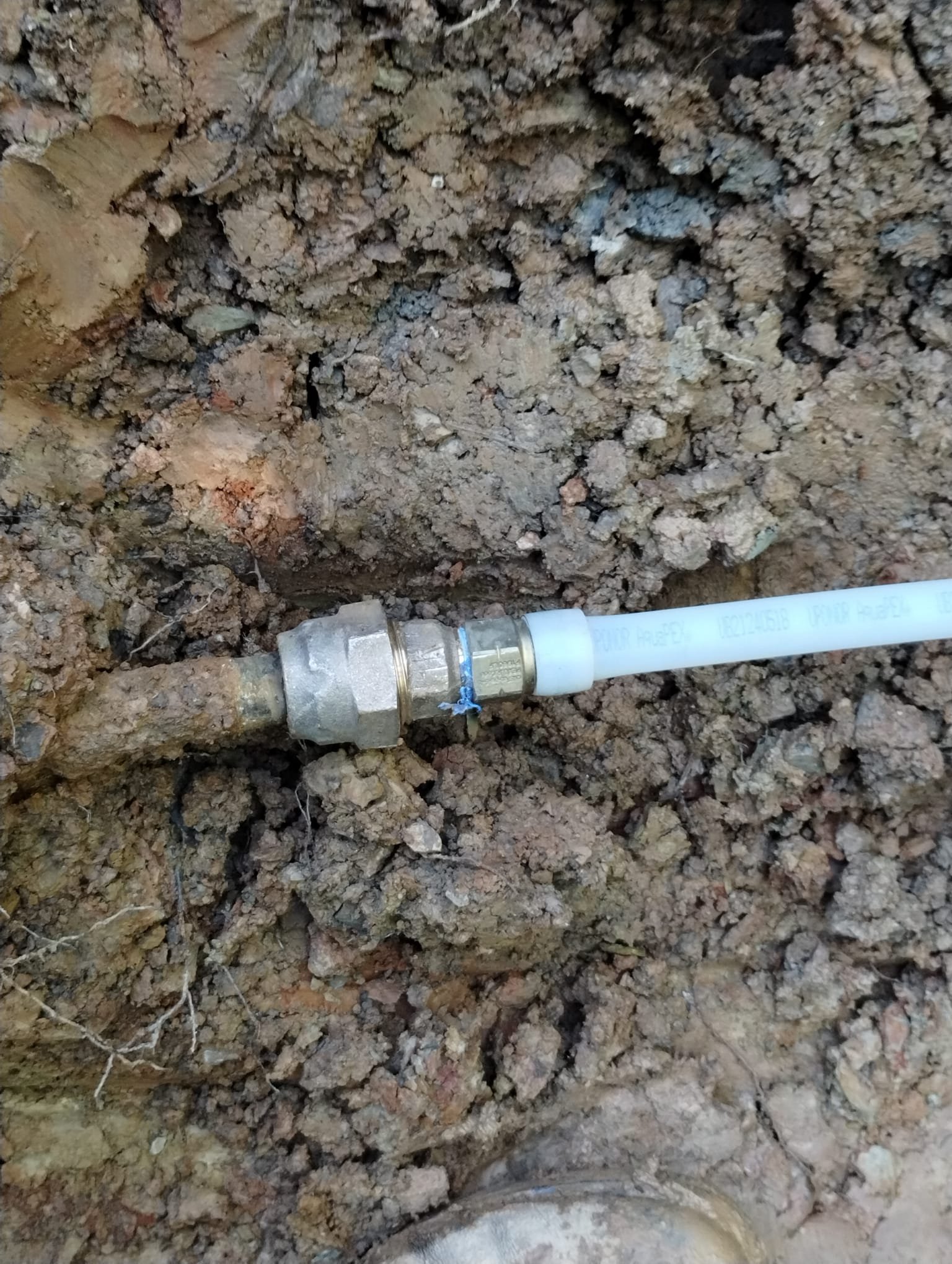 A newly connected underground water line in an open trench