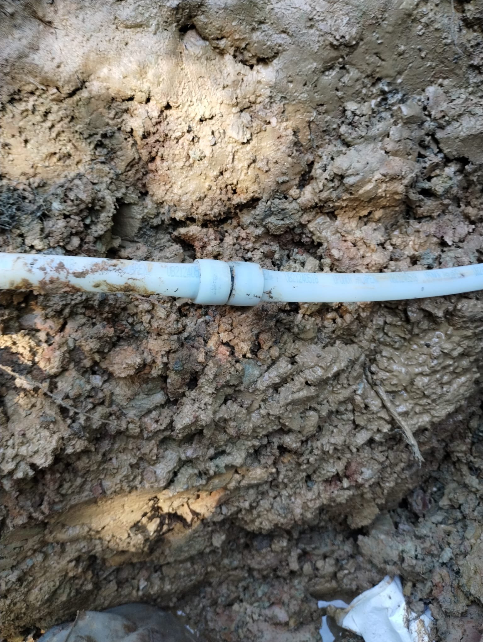 A finished underground pipe installation in a trench before backfilling