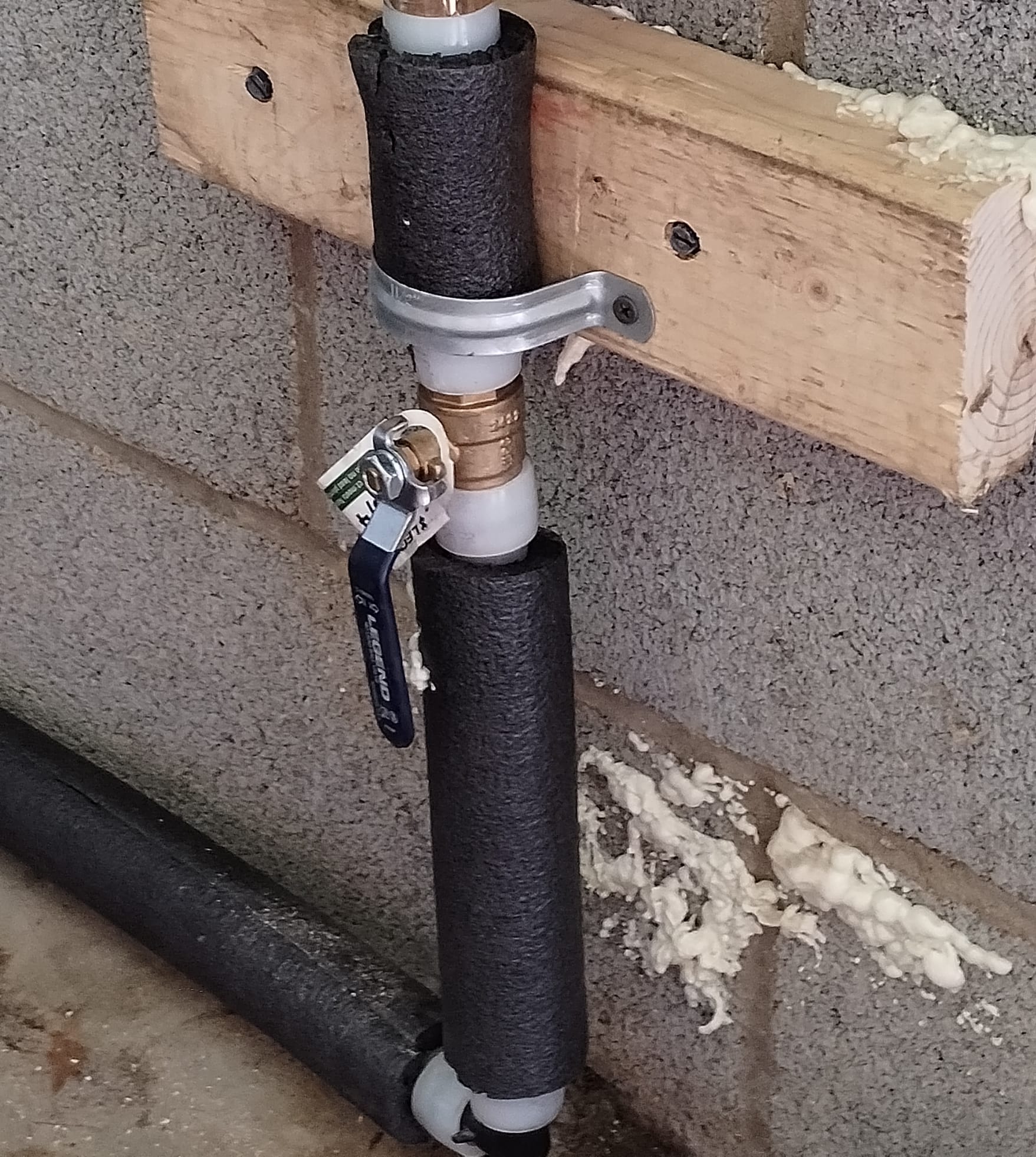 A new shutoff valve and insulated pipe installed along a wall