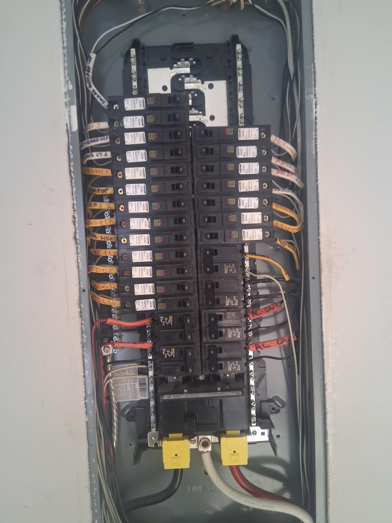 Open residential electrical panel with labeled circuits and newer breakers