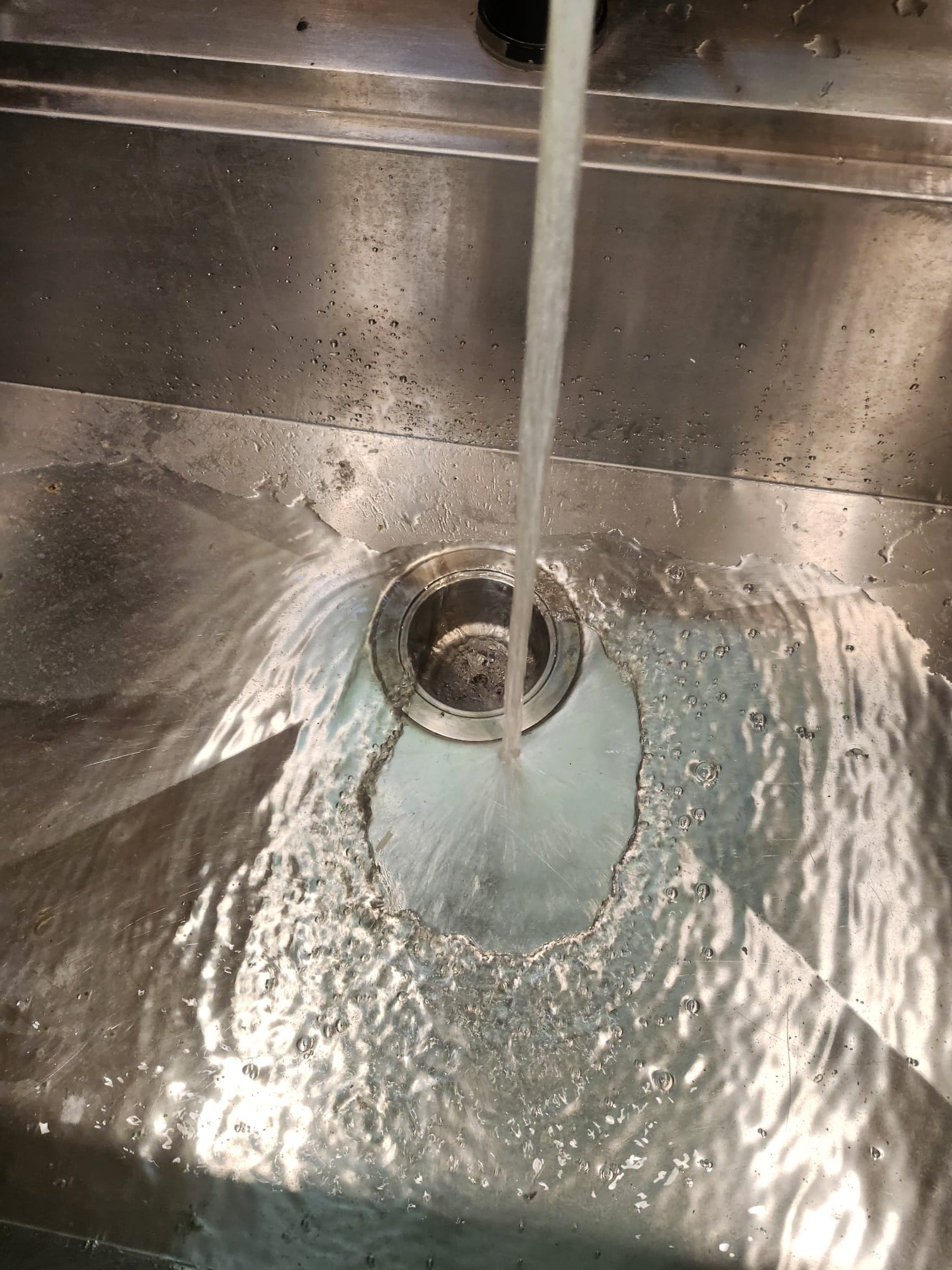 Water flowing through a kitchen sink as part of a drain test