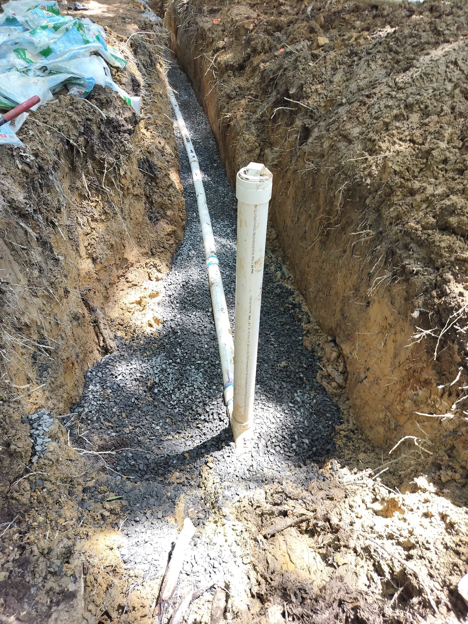 A newly installed cleanout riser standing in a trench