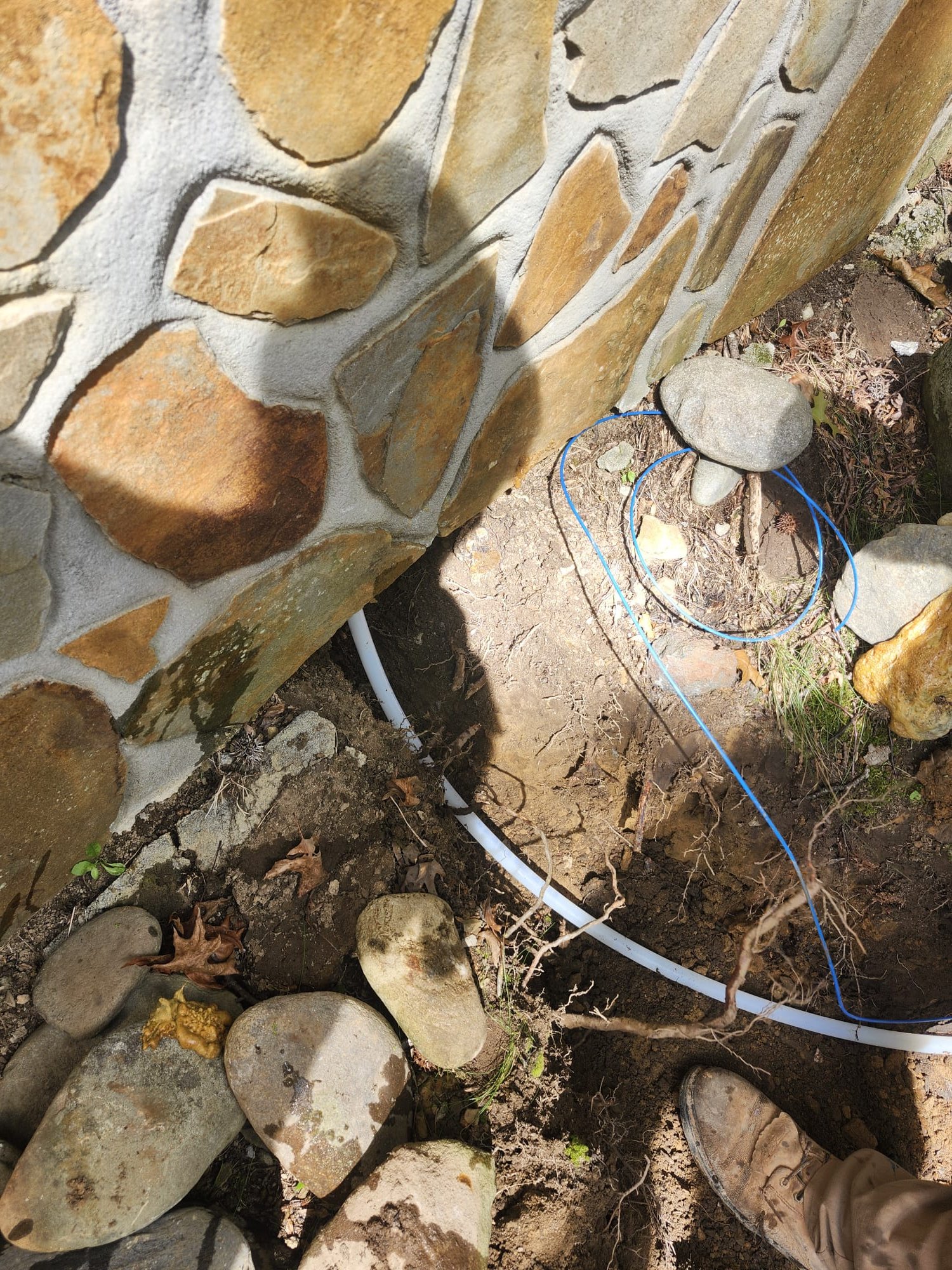 A clean pipe installed along a foundation during an underground plumbing project