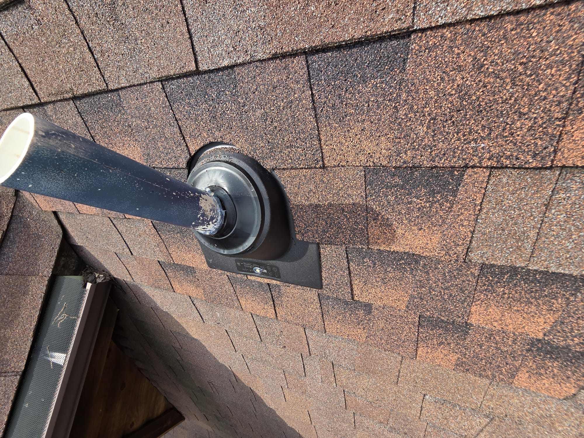 New vent boot and flashing installed around a roof pipe