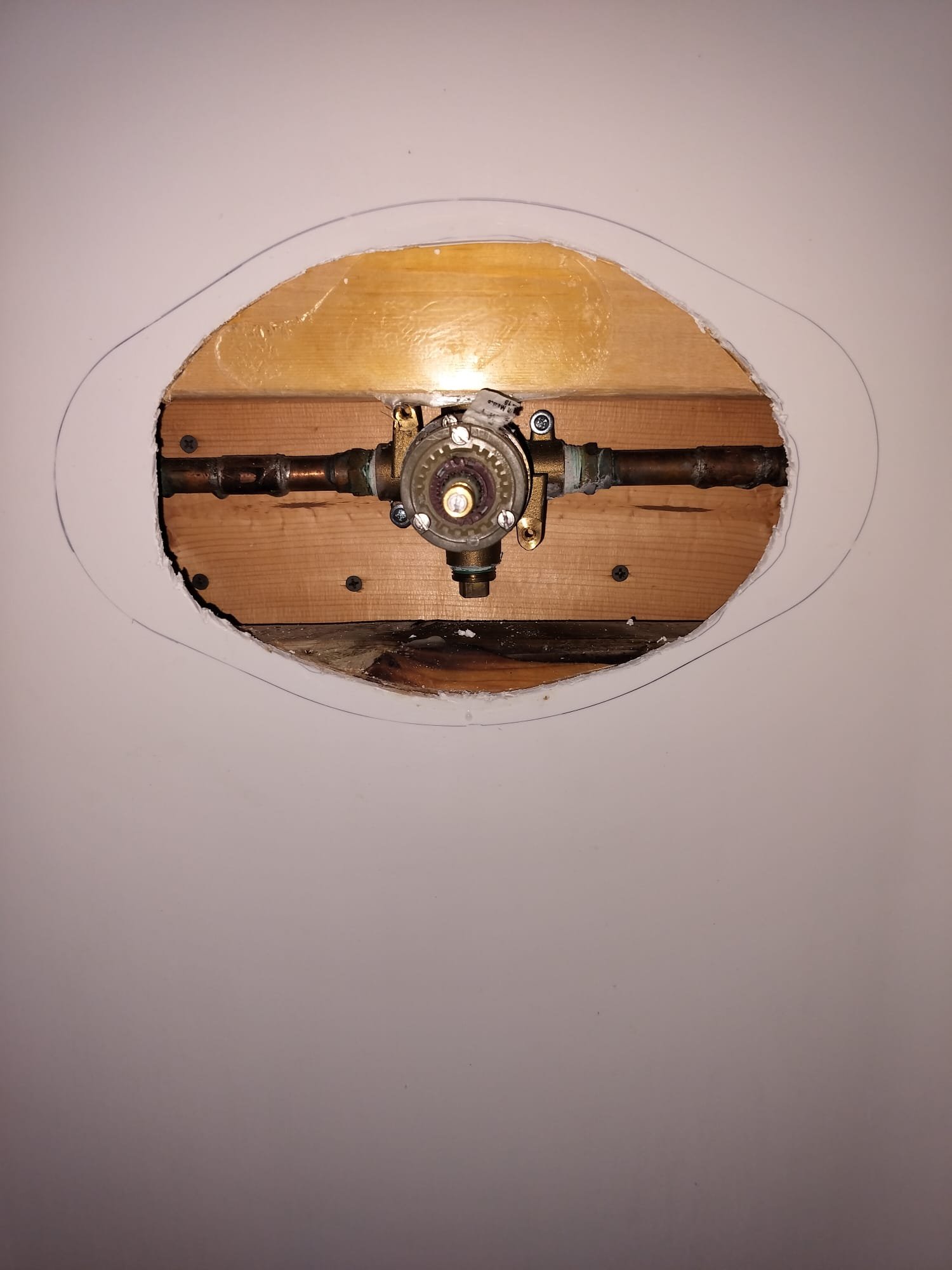 Opened wall area showing shower plumbing access