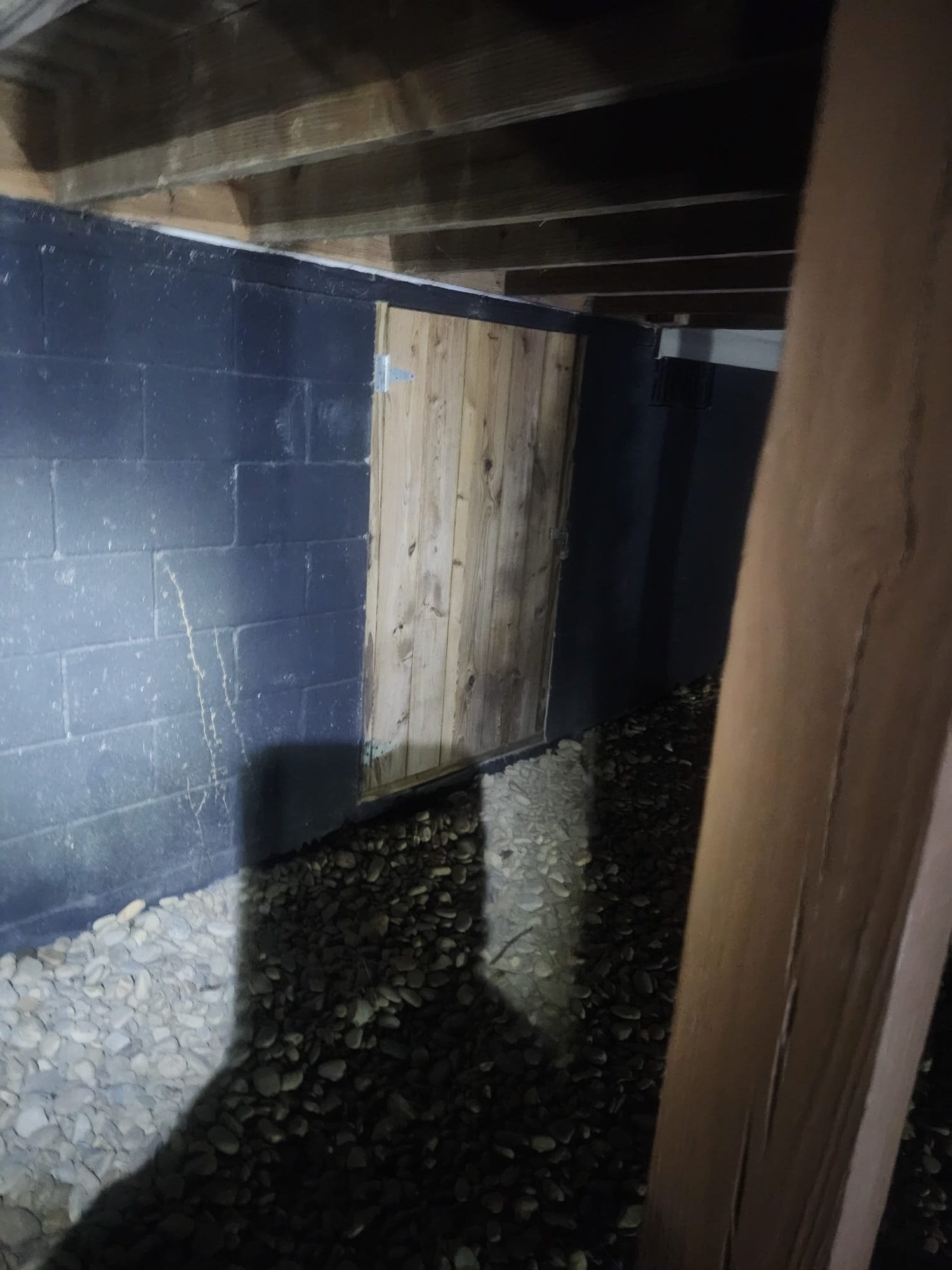 Crawl space access area with a wooden panel