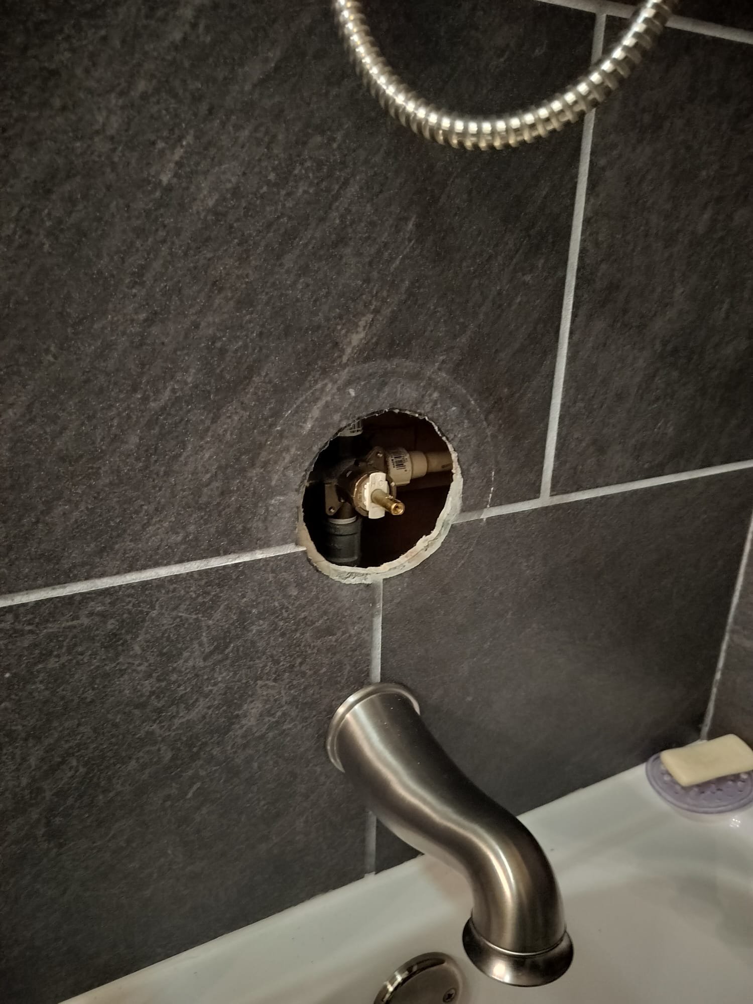 Access opening around a shower valve during plumbing work