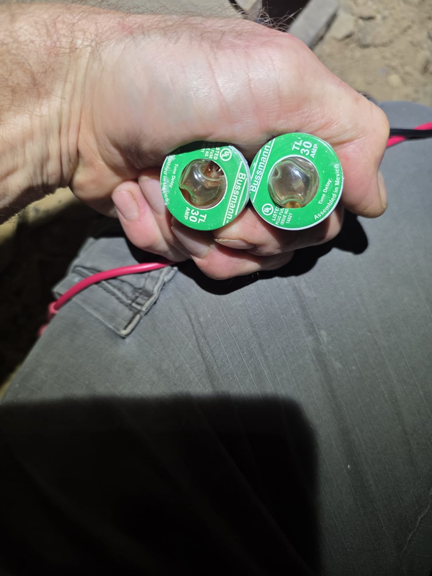 Technician holding replacement fuses during troubleshooting