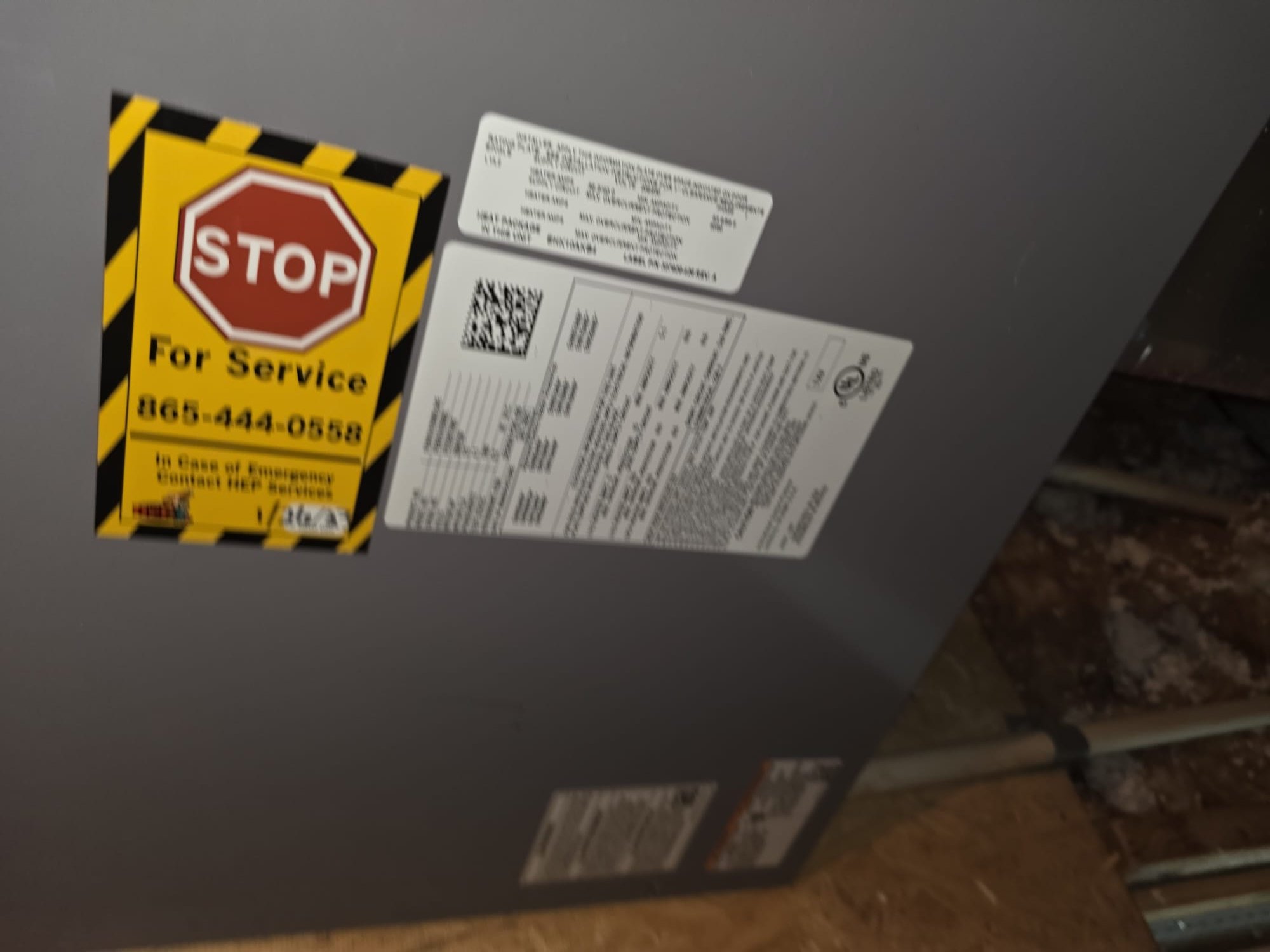 Installed indoor HVAC unit with service documentation labels