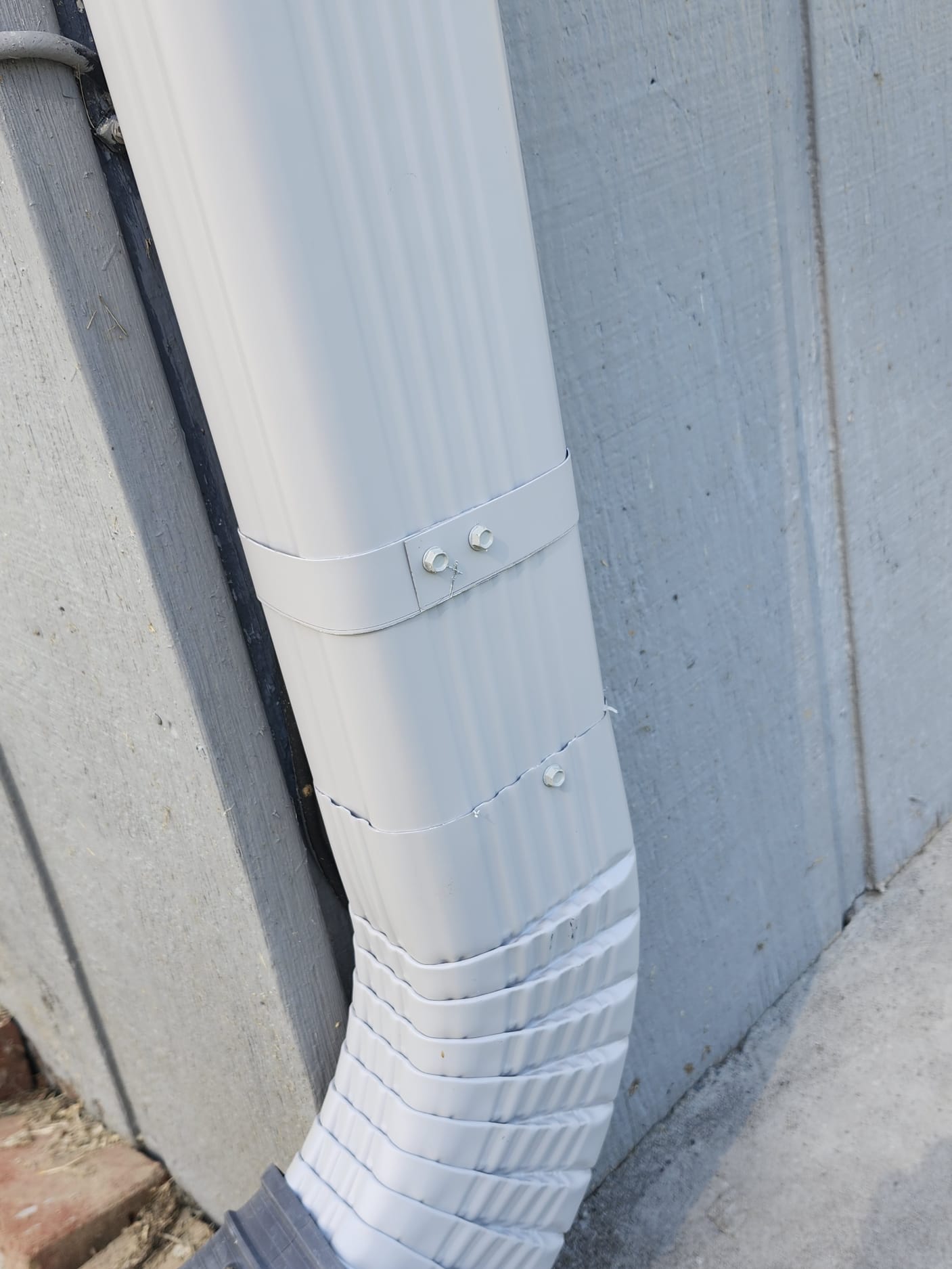 A new downspout section helping move water away from the wall