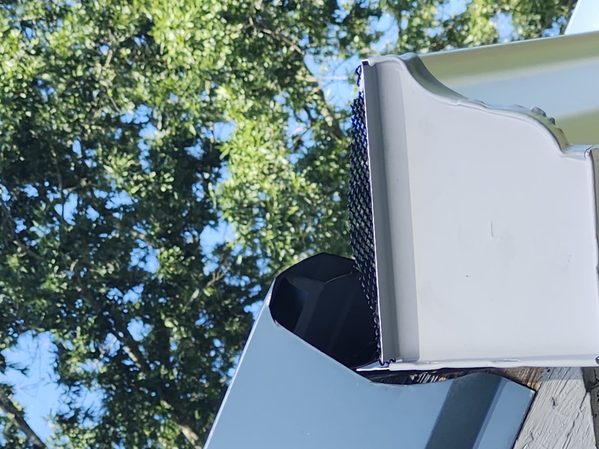 A close-up of a newer gutter guard and roof-edge detail