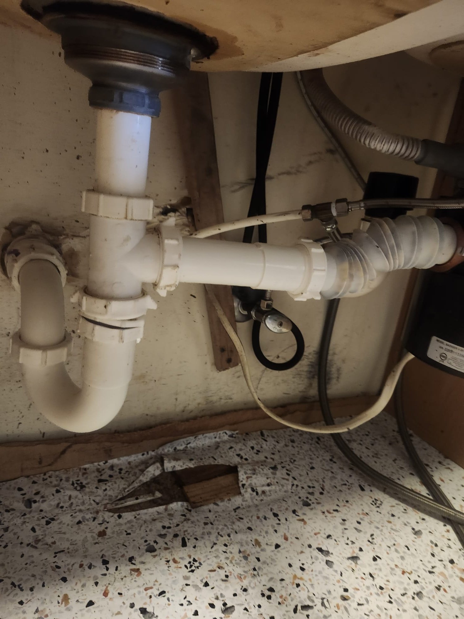 Older under-sink drain plumbing that can trap grease and debris