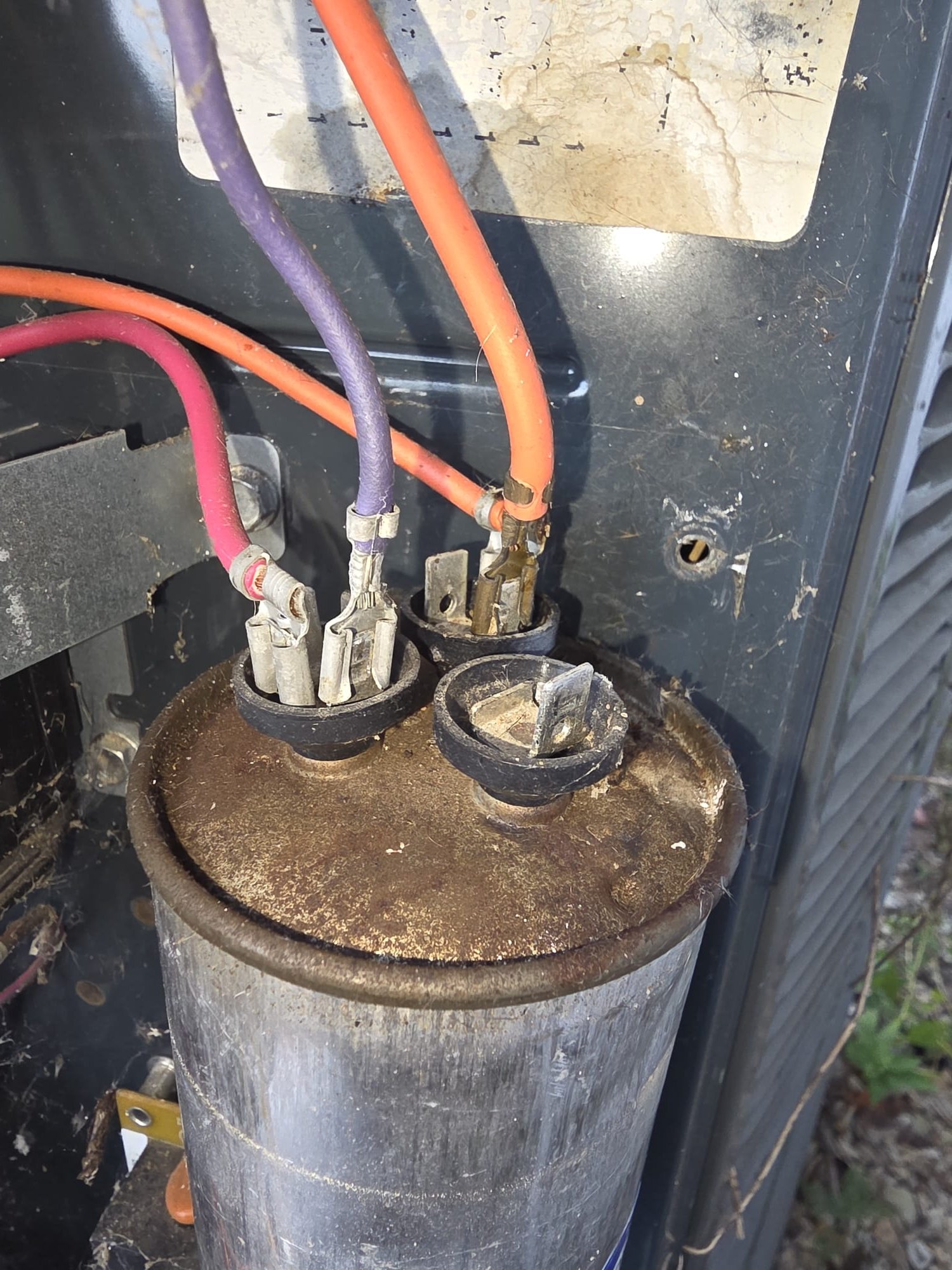 Old, worn electrical component inside an outdoor HVAC unit